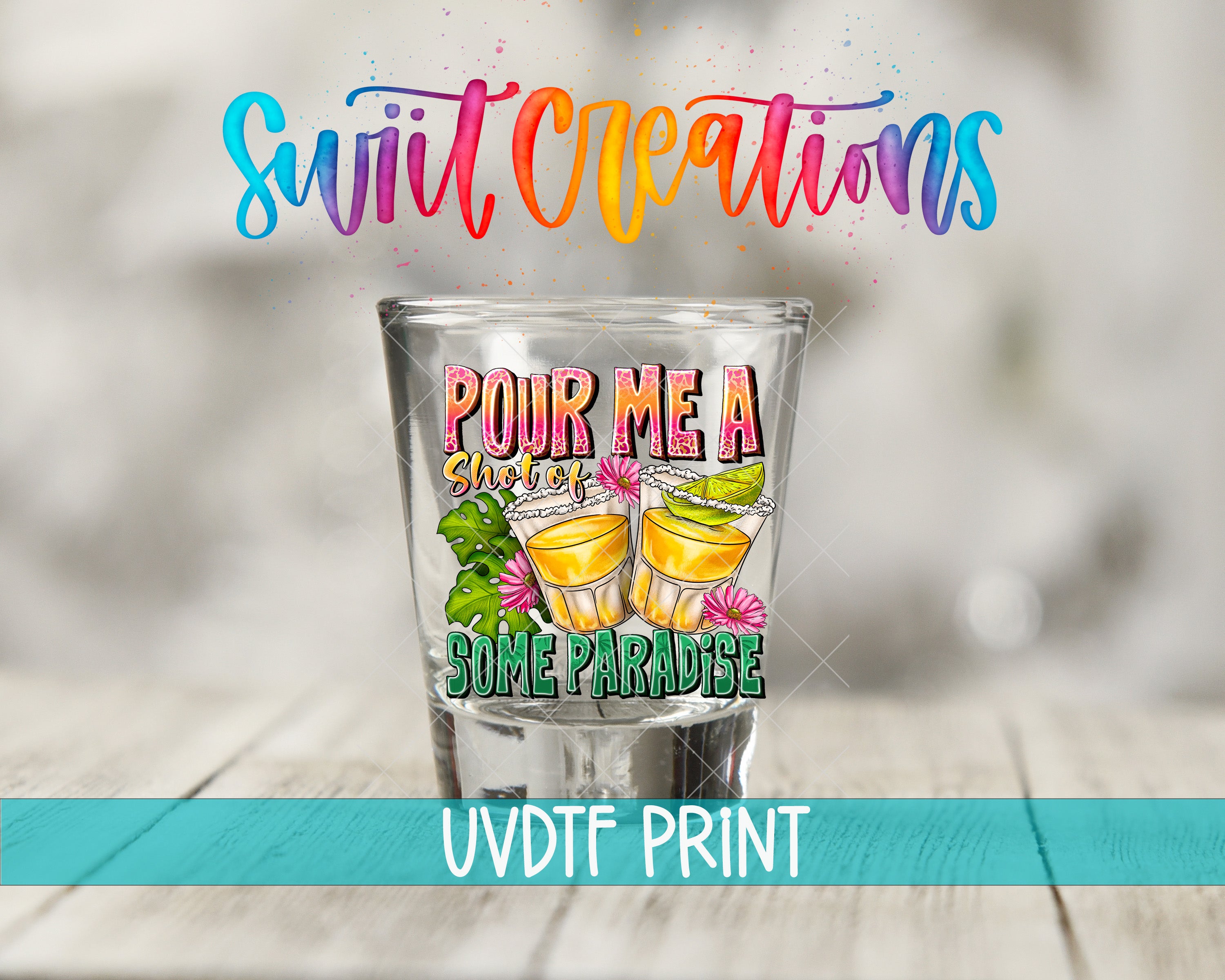 a shot glass with a colorful design and text, placed on a wooden surface.