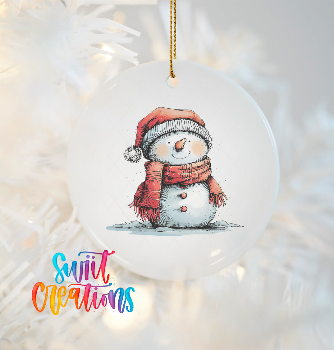 A snowman ornament with a red scarf and hat, sitting on a snowy surface, is hanging from a string.