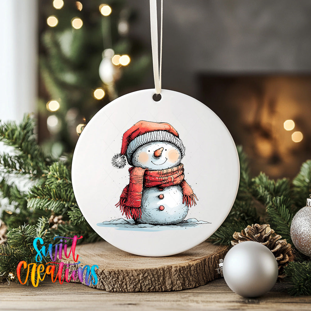 A white ceramic ornament featuring a snowman wearing a red scarf and hat, surrounded by Christmas decorations and greenery.