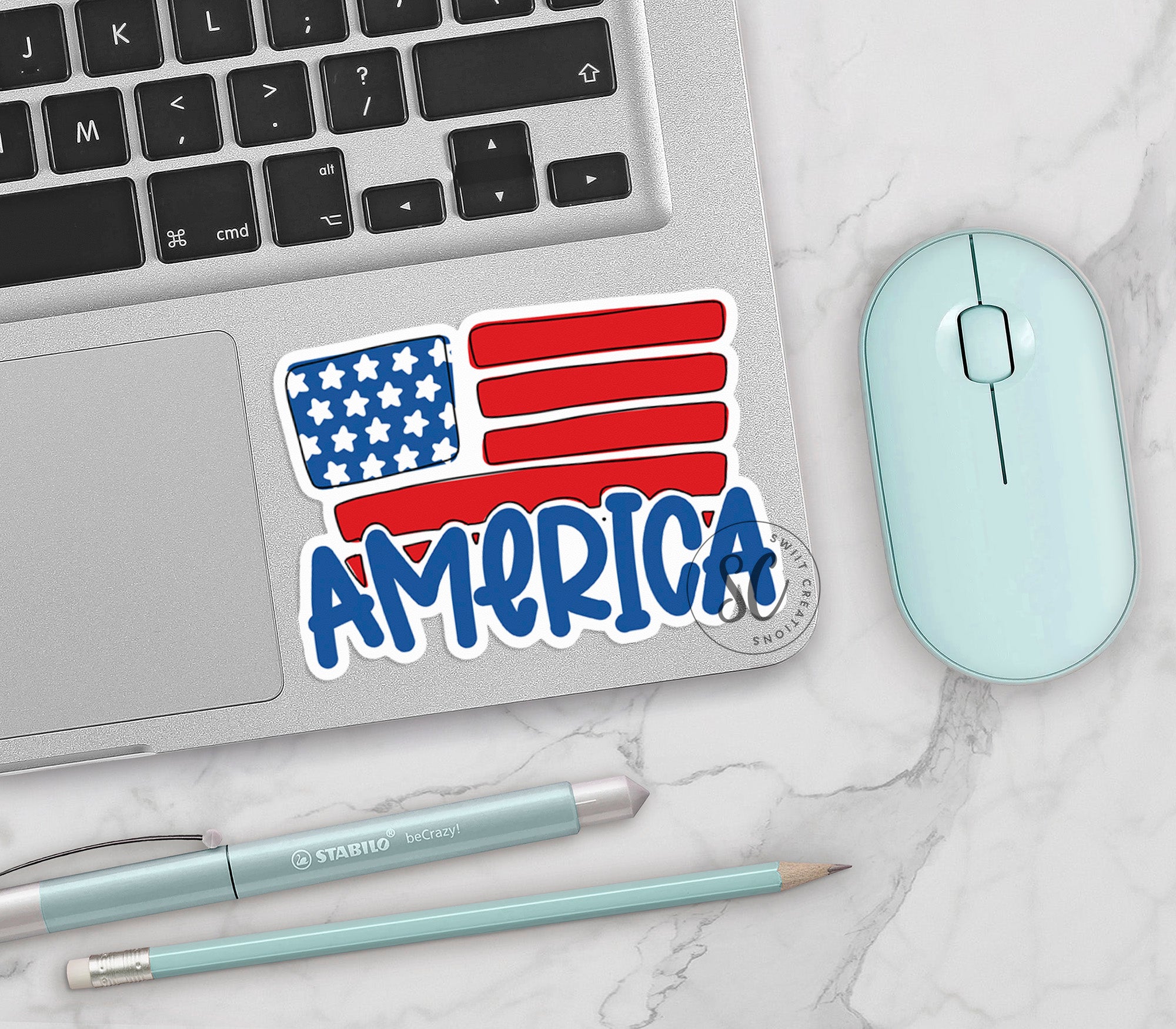 an american sticker on a laptop next to a mouse