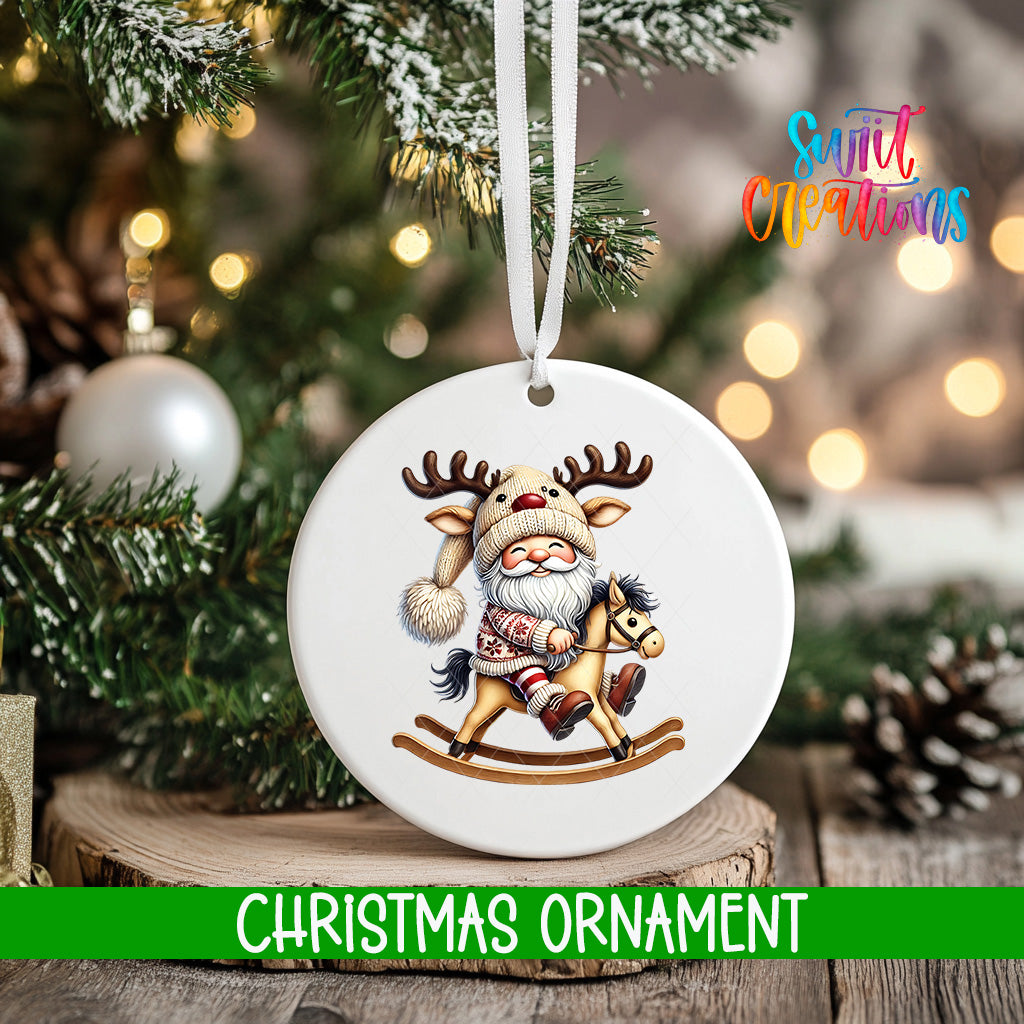 A white Christmas ornament featuring a Santa Claus figure riding a rocking horse, with a snowy background and twinkling lights.