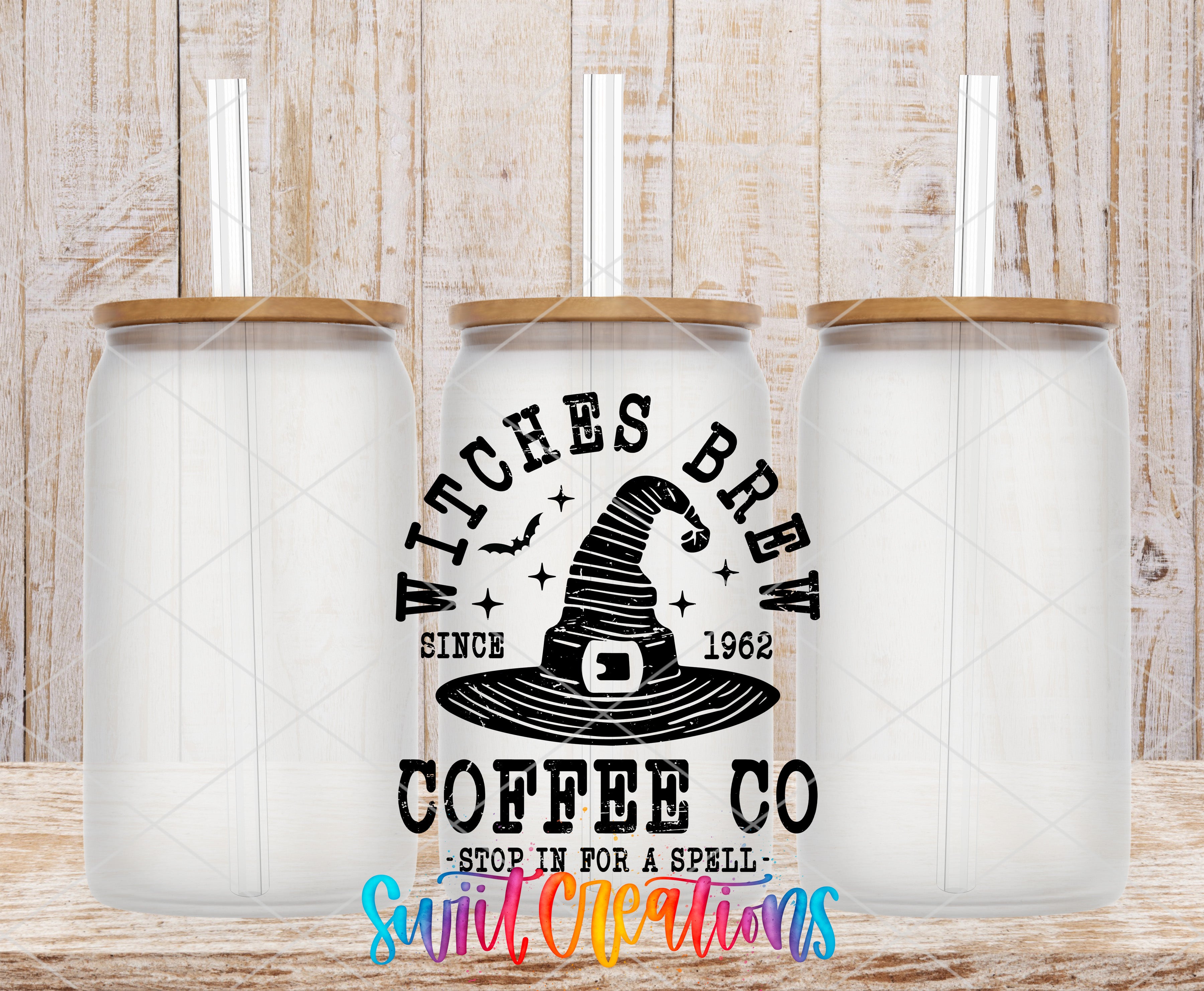 three clear glass jars with lids, each containing a straw, arranged in a row against a wooden background. The jars have a label that reads "Witches Brew" and "Since 1962", indicating that they are part of a coffee company. The label also includes the phrase "Stop in for a spell" and "Suit Creations", suggesting that the jars are designed to be used for coffee-making and possibly for some sort of magical or mystical purpose.