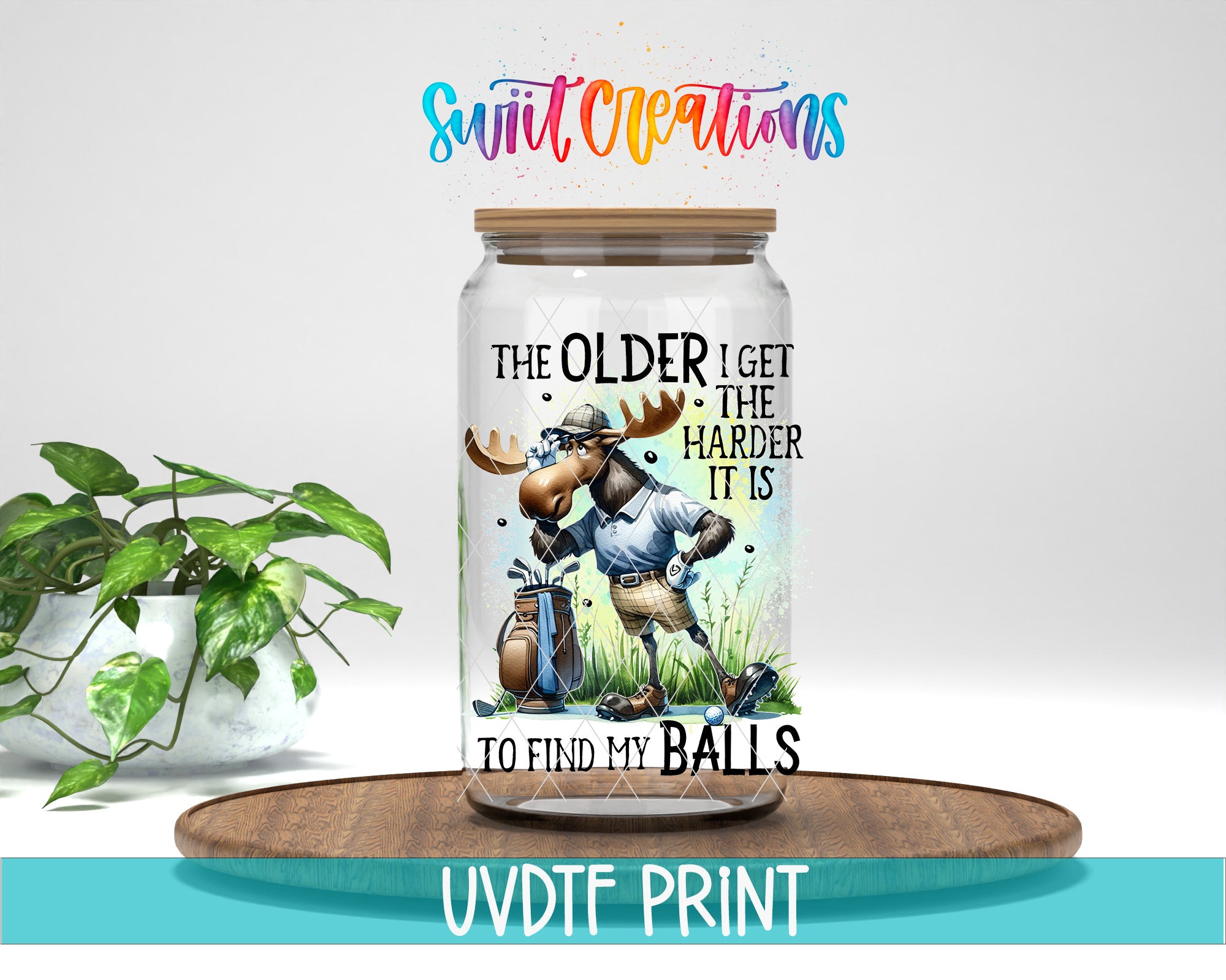 A glass jar with a cartoon moose and the text "The older I get, the harder it is to find my balls" printed on it, placed on a wooden surface.