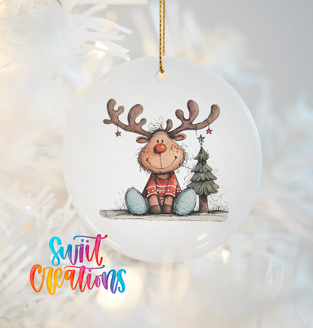 A white ornament featuring a smiling reindeer with antlers and a Christmas tree.