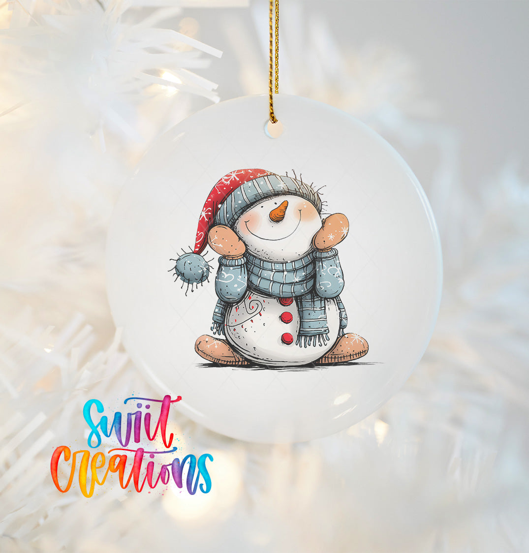 A white ornament featuring a smiling snowman wearing a red hat and blue scarf, hanging on a string.