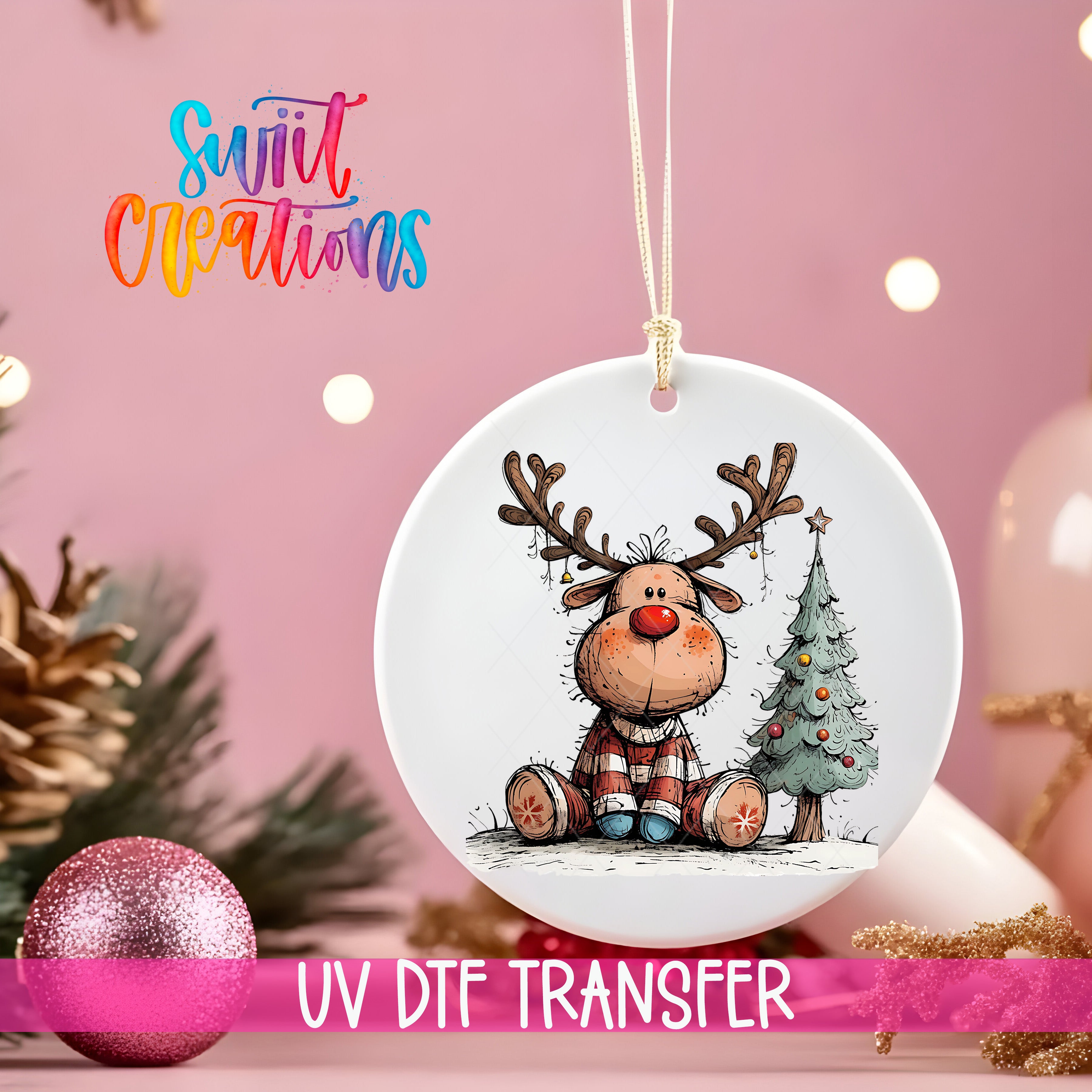 A white ornament with a cartoon reindeer and a Christmas tree is hanging on a pink background, with a pink glitter ball and pine cones in the foreground.