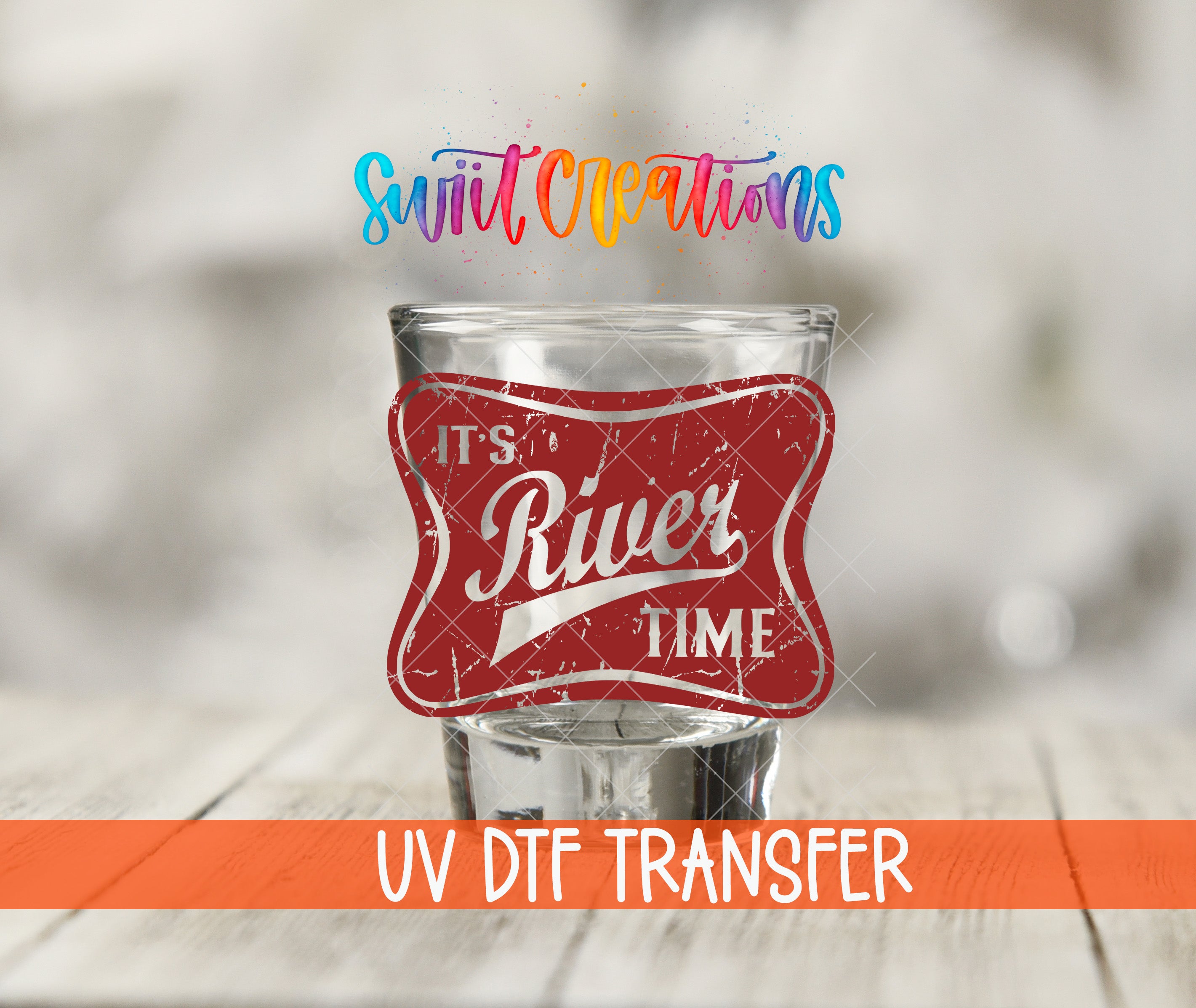 a glass with a red label that says "It's River Time" and is placed on a wooden surface.