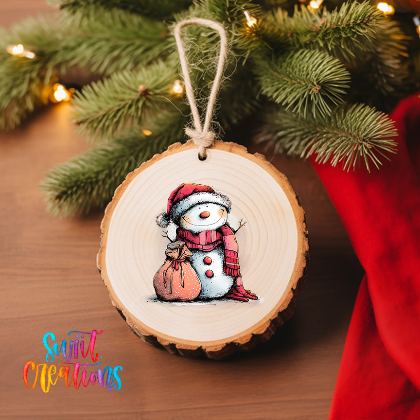 A wooden ornament featuring a snowman is hanging on a Christmas tree, surrounded by pine branches and twinkling lights.