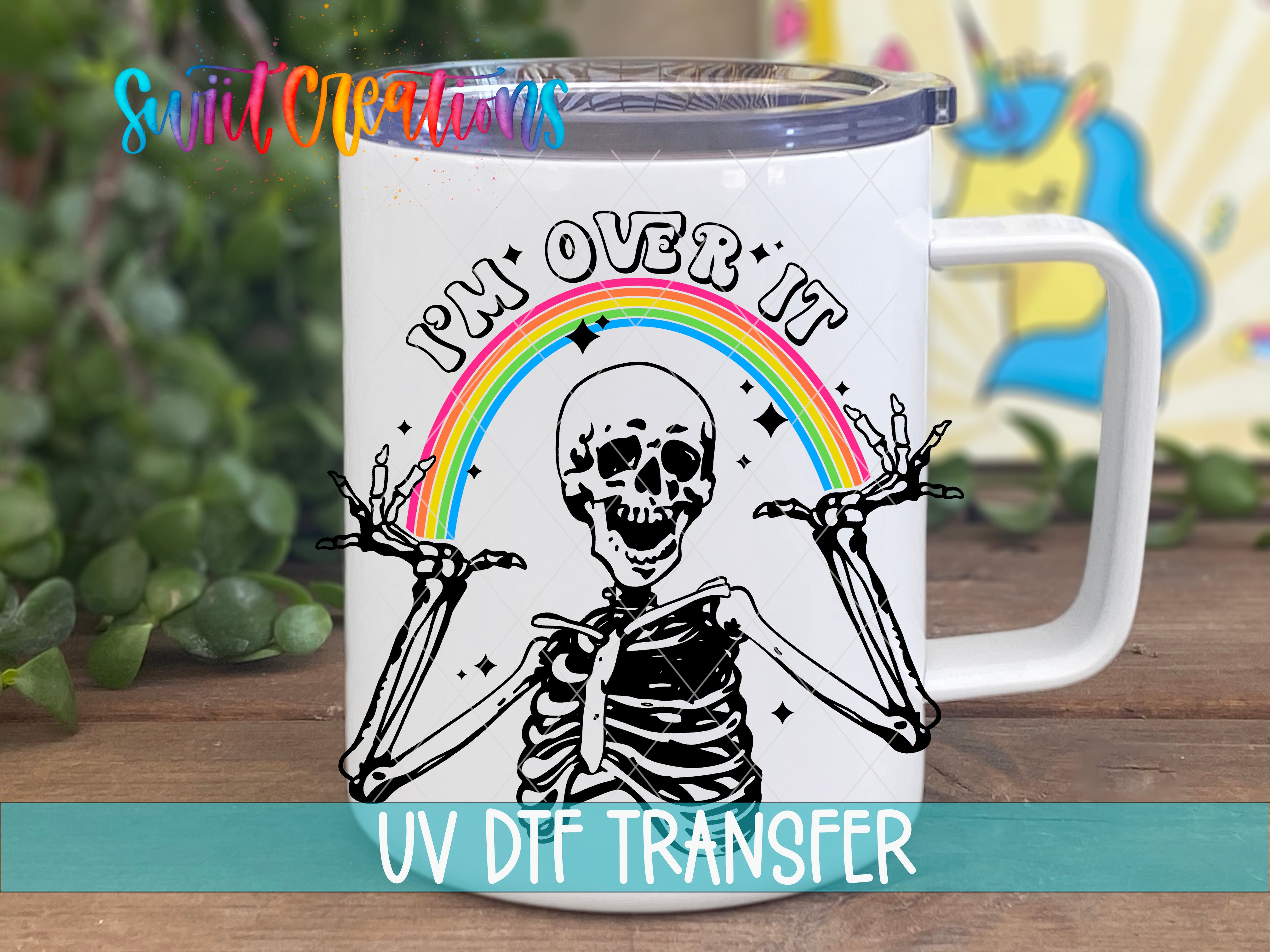 Swiit Creations UV DTF Sassy Skeleton I’m Over It Rainbow transfer displayed on a white coffee mug