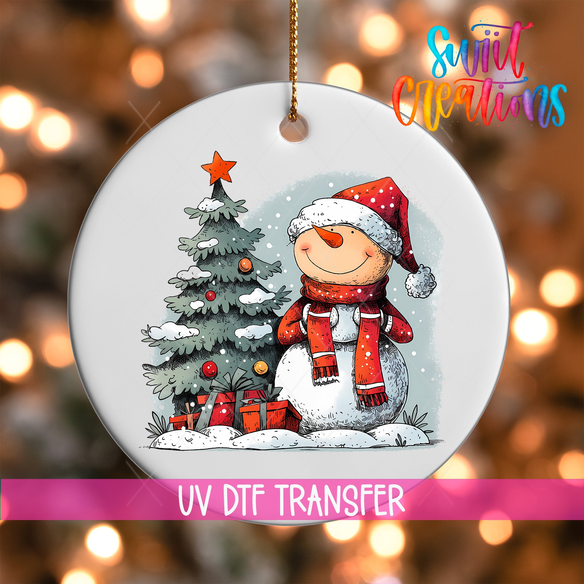 A white ornament with a snowman and a Christmas tree, with a pink ribbon around it.