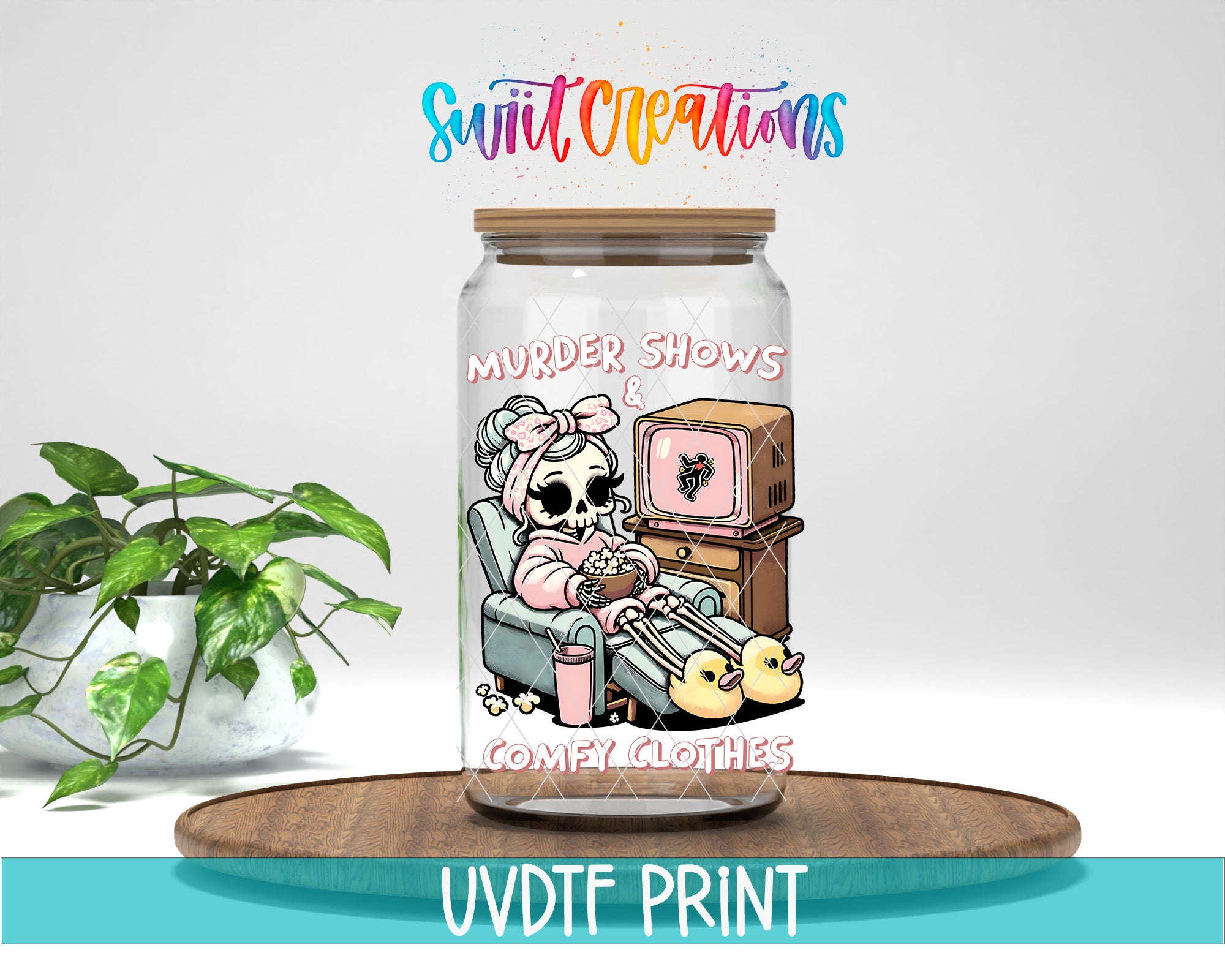 A glass jar with a cartoon illustration of a skeleton wearing a pink outfit and holding a cup, sitting in a chair and watching television. The jar has a label that says "Murder Shows" and "Comfy Clothes". The jar is placed on a wooden surface, and there is a plant in the background.