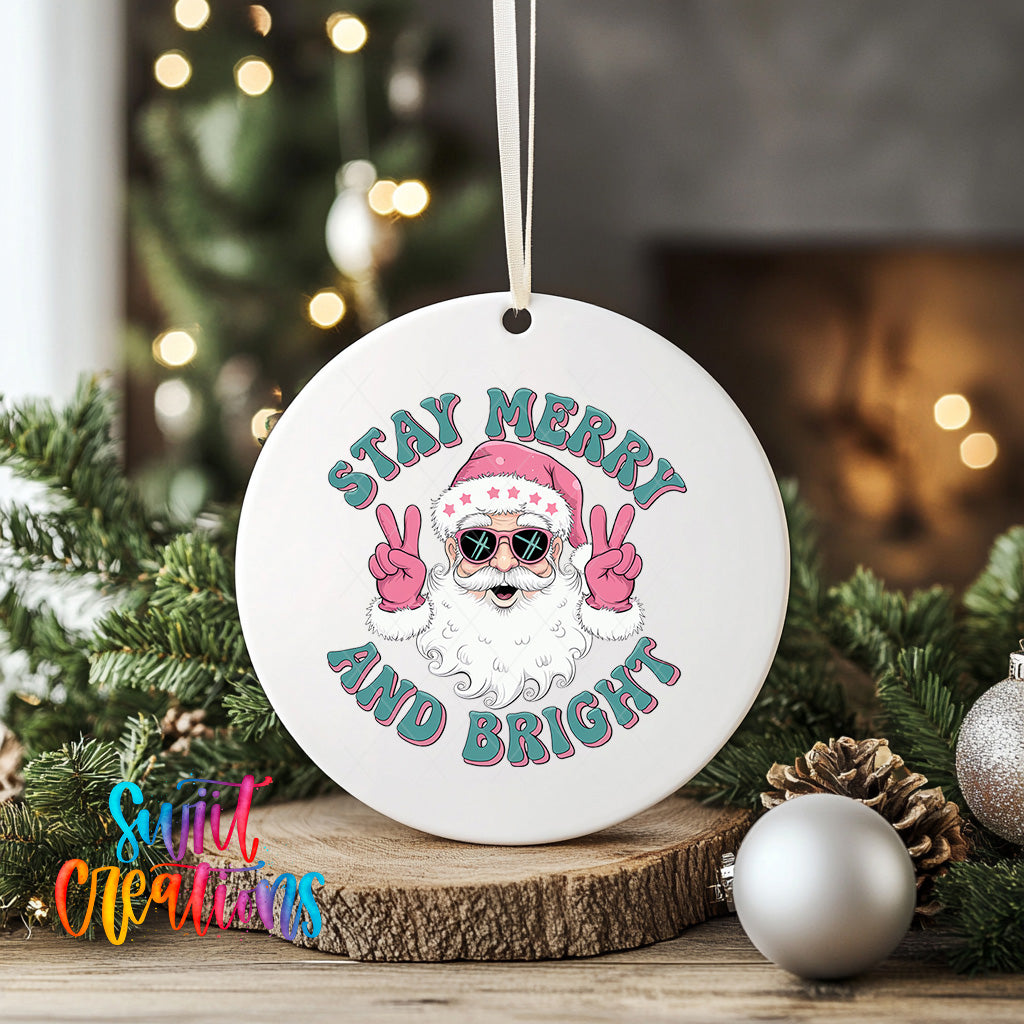 A white ornament with a Santa Claus image and the text "Stay Merry and Bright" is displayed on a wooden surface, surrounded by Christmas decorations and greenery.