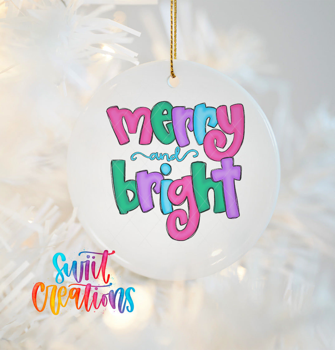 A white ornament with colorful text that says "merry and bright" hanging on a Christmas tree.