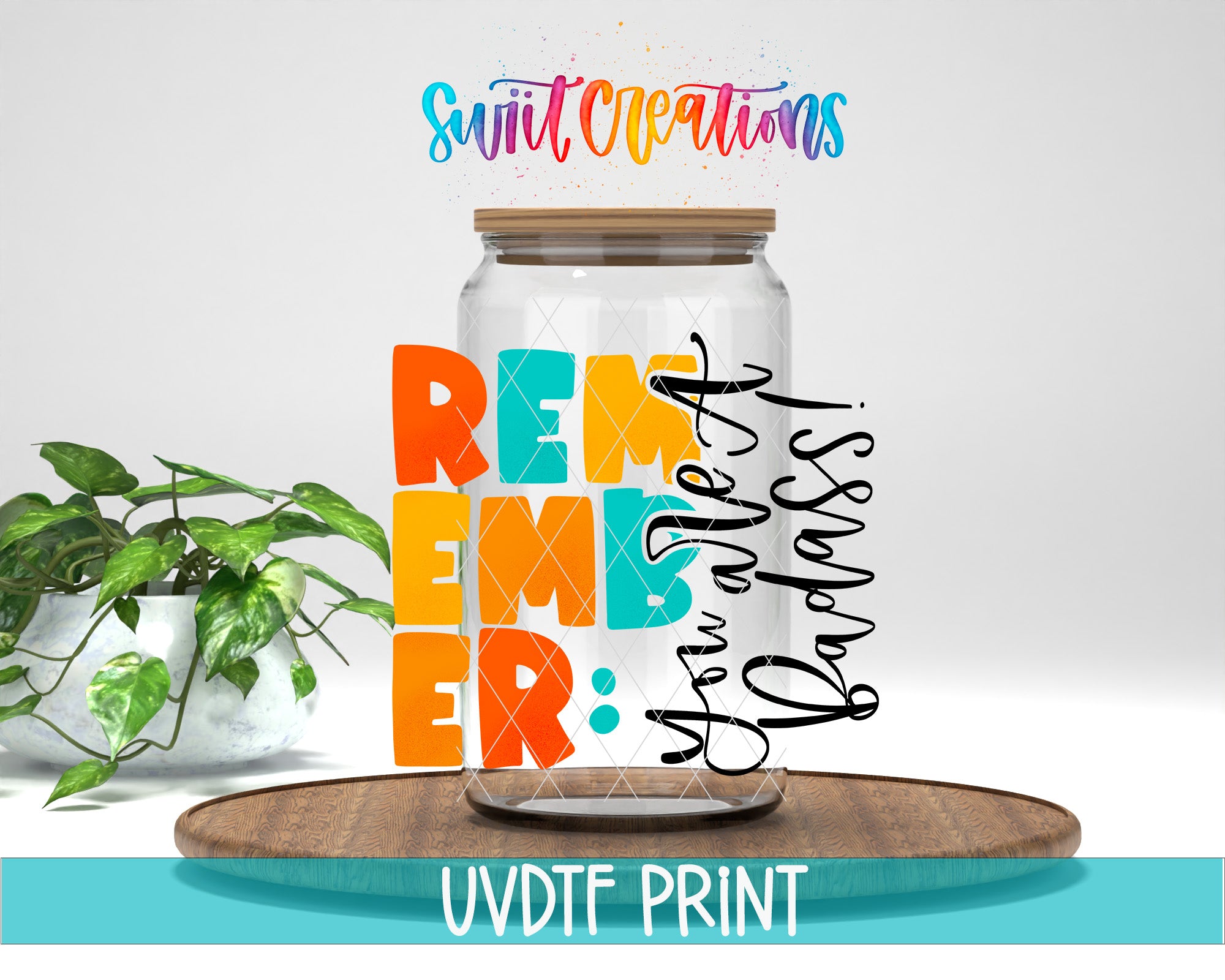 a large glass jar with a wooden lid, placed on a wooden surface. The jar has a label with the text "Remember: You are loved" written on it. There is also a potted plant in the background.