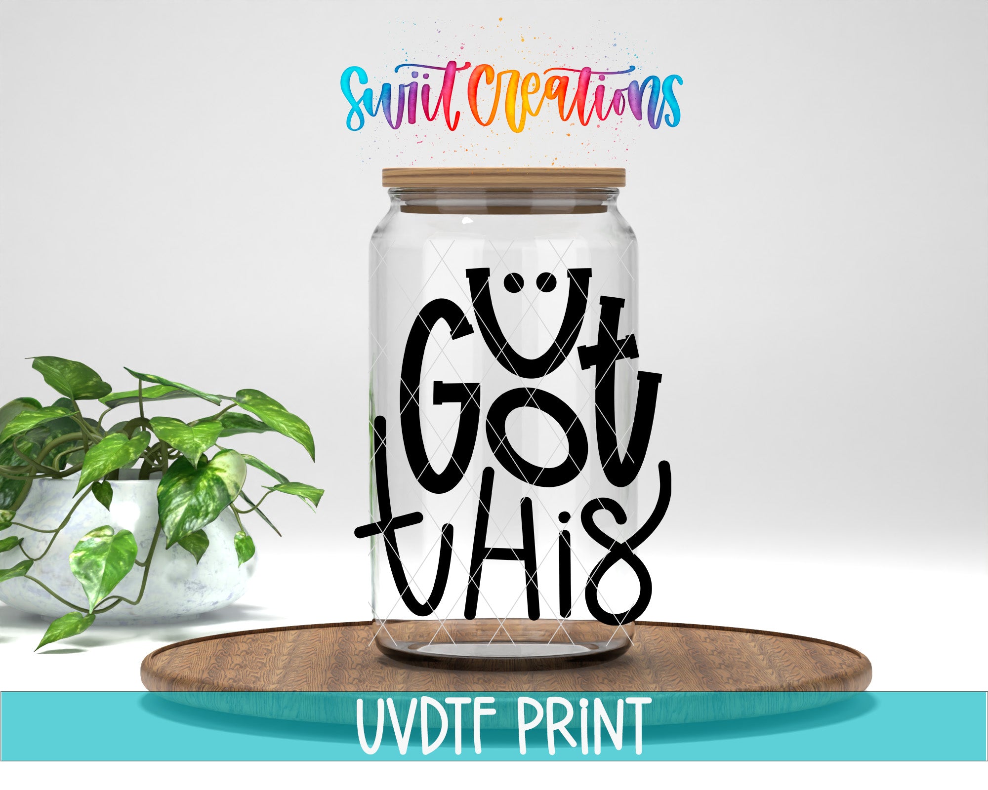 A glass jar with a lid, featuring a hand-drawn smiley face and the text "GOT THIS" written on it. The jar is placed on a wooden surface, and there is a potted plant in the background.