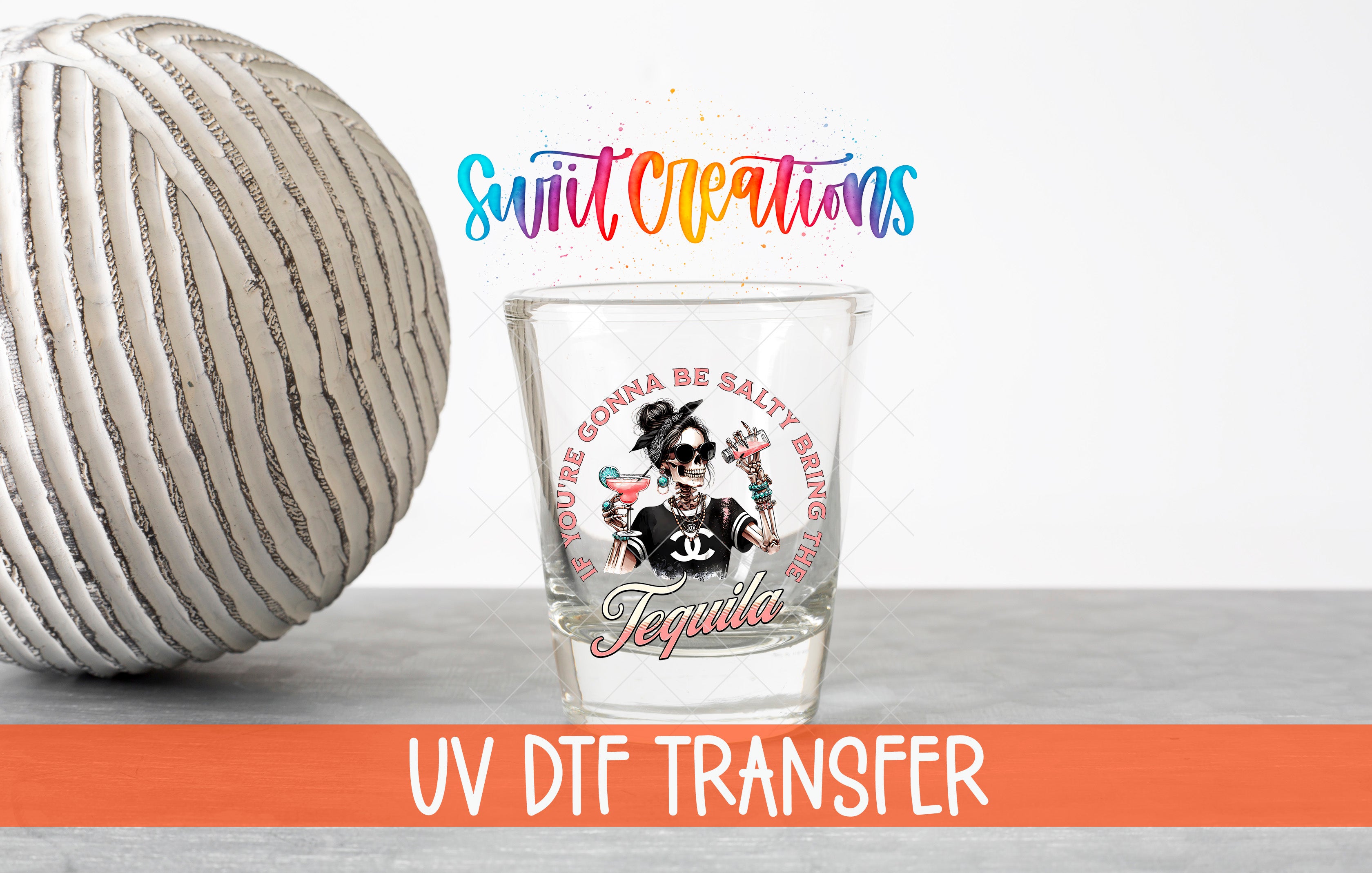 a shot glass with a tequila-themed design, accompanied by a large white ball and a colorful text overlay.