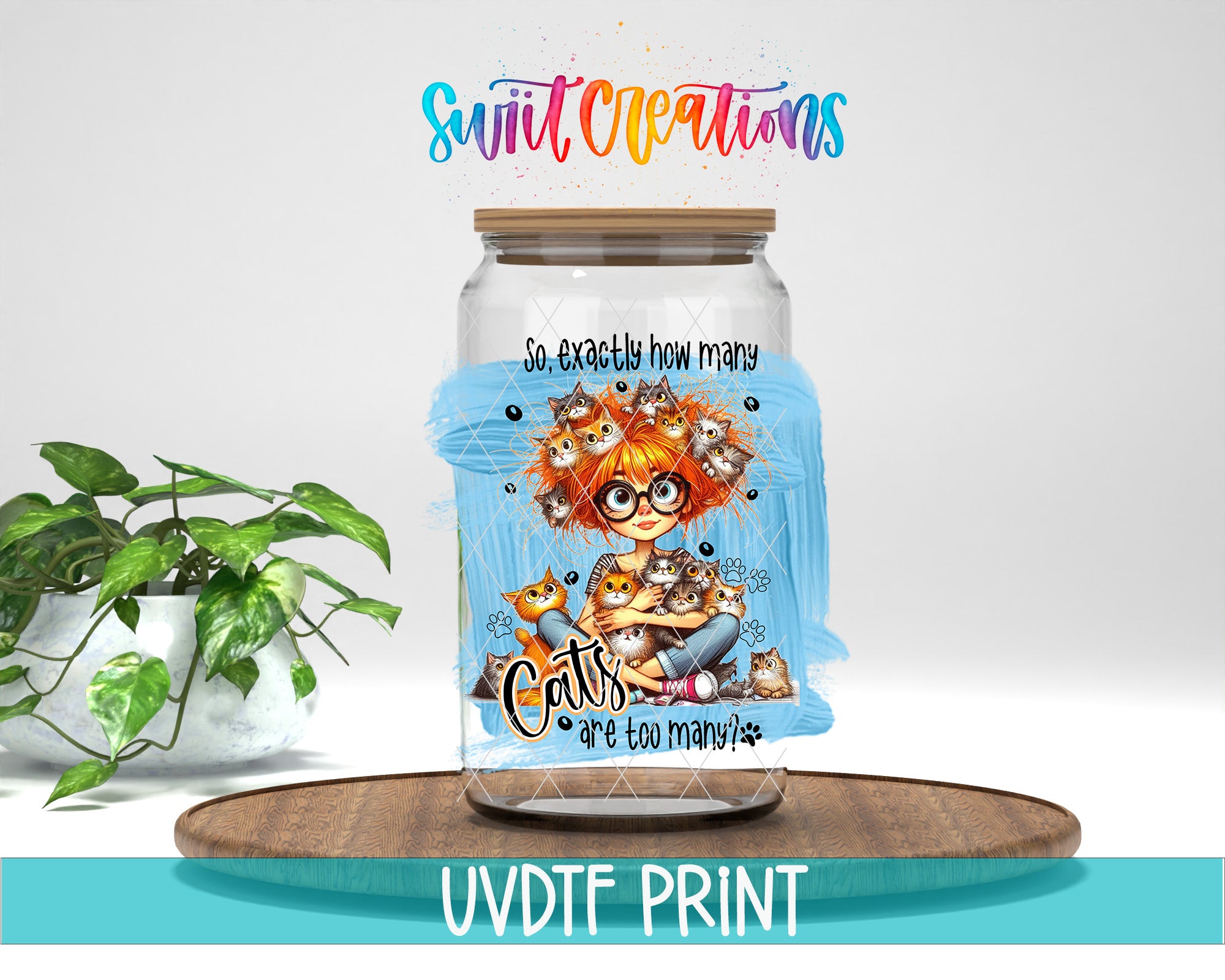 A glass jar with a colorful illustration of a cat and the text "So exactly how many cats are you too many?" on it, placed on a wooden surface. There is also a plant in the background.
