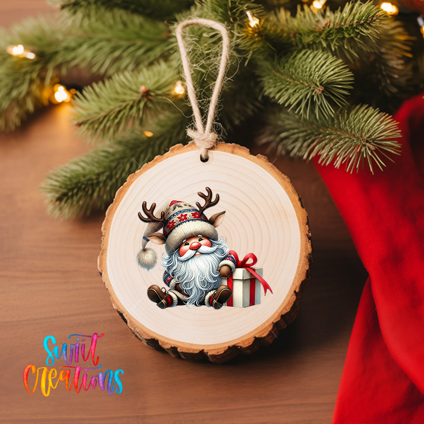 A wooden ornament featuring a smiling Santa Claus figure holding a gift box, hanging on a Christmas tree.