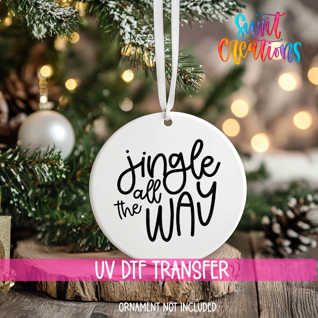 A white ornament with the text "Jingle all the way" hanging from a Christmas tree.