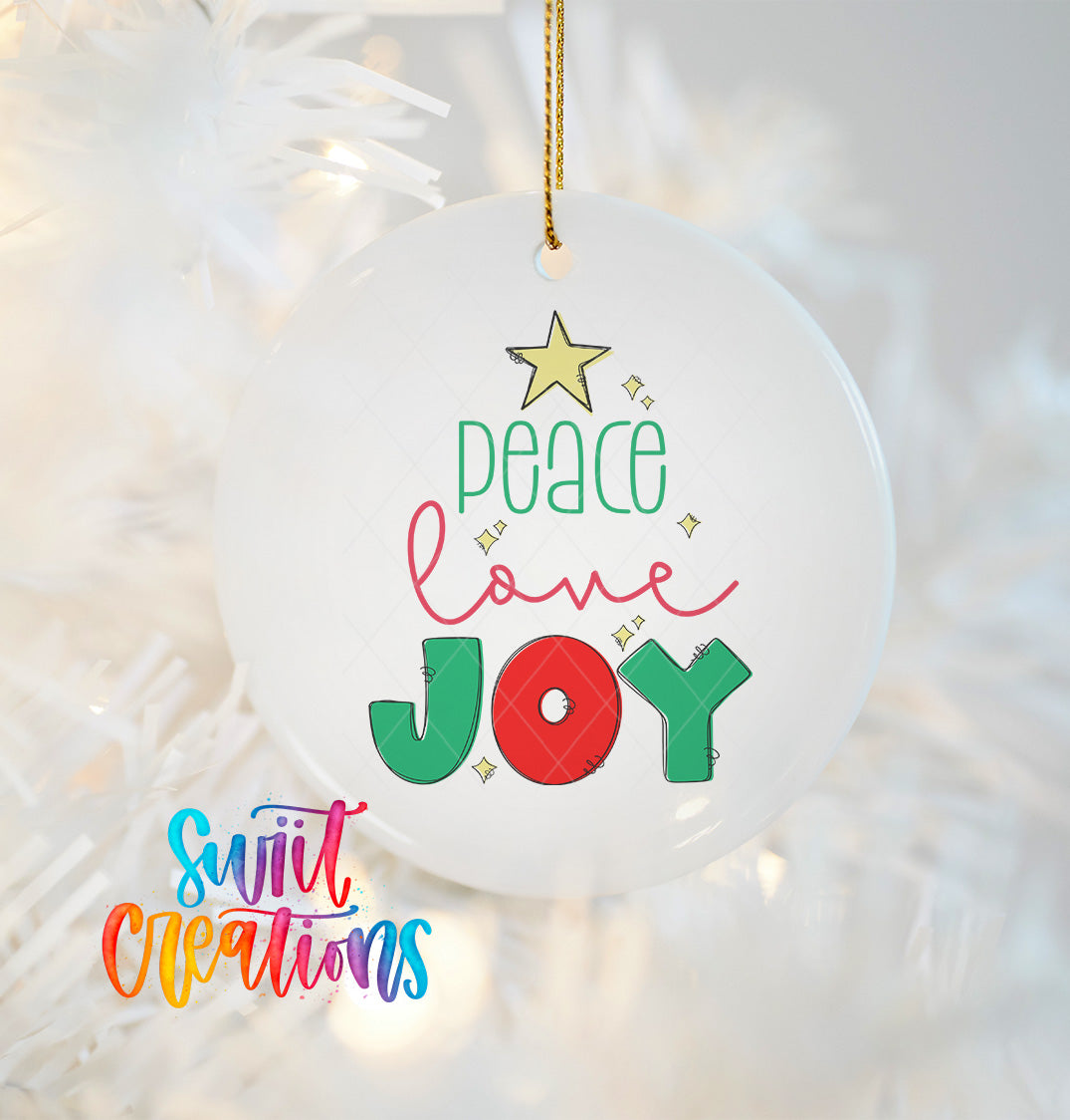 A white ornament with a Christmas tree design and the text "Peace love joy" hanging on a string.