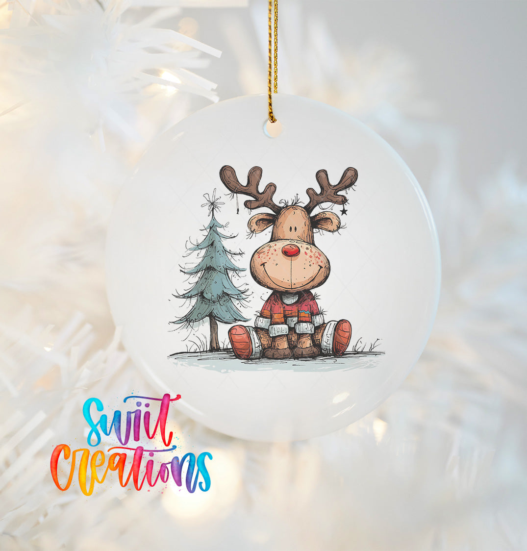 A white ornament featuring a cartoon reindeer sitting next to a Christmas tree.