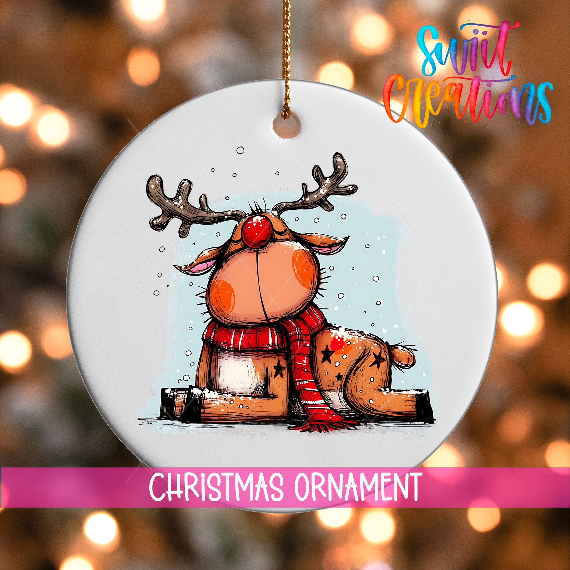 A white Christmas ornament featuring a cartoon reindeer with antlers and a red nose, sitting on a snowy surface.