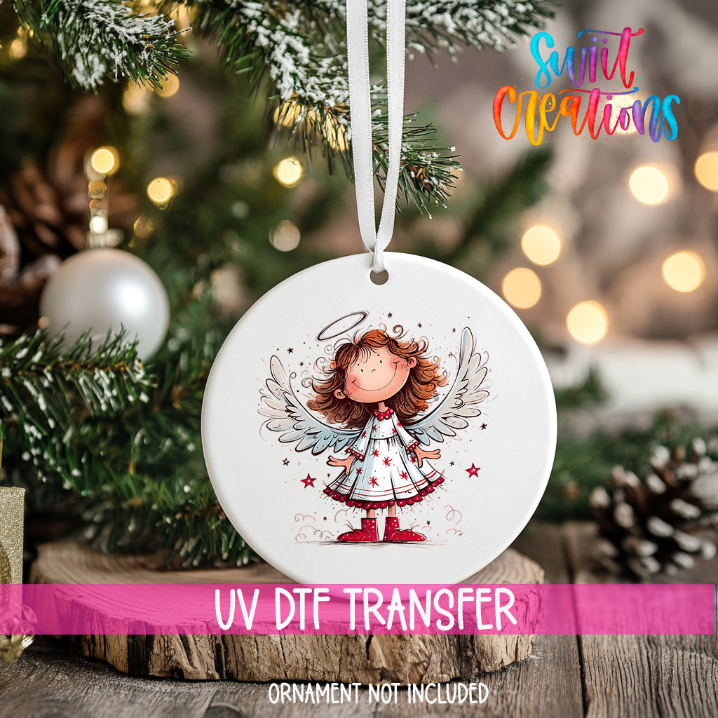A white ceramic ornament with a cartoon illustration of a smiling girl with wings, hanging on a Christmas tree.