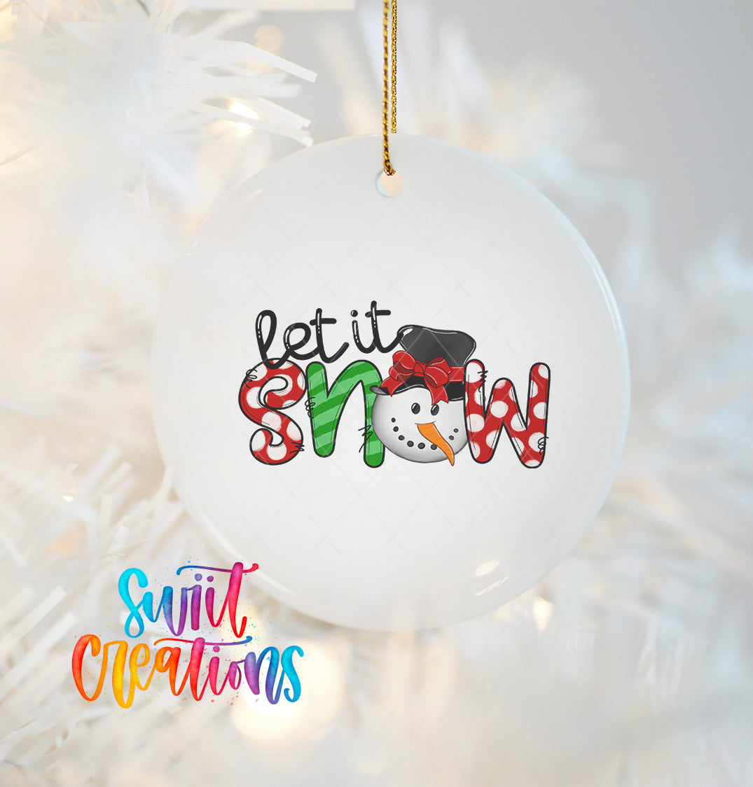 A white ornament with a snowman design and the text "let it snow" hanging from a string.