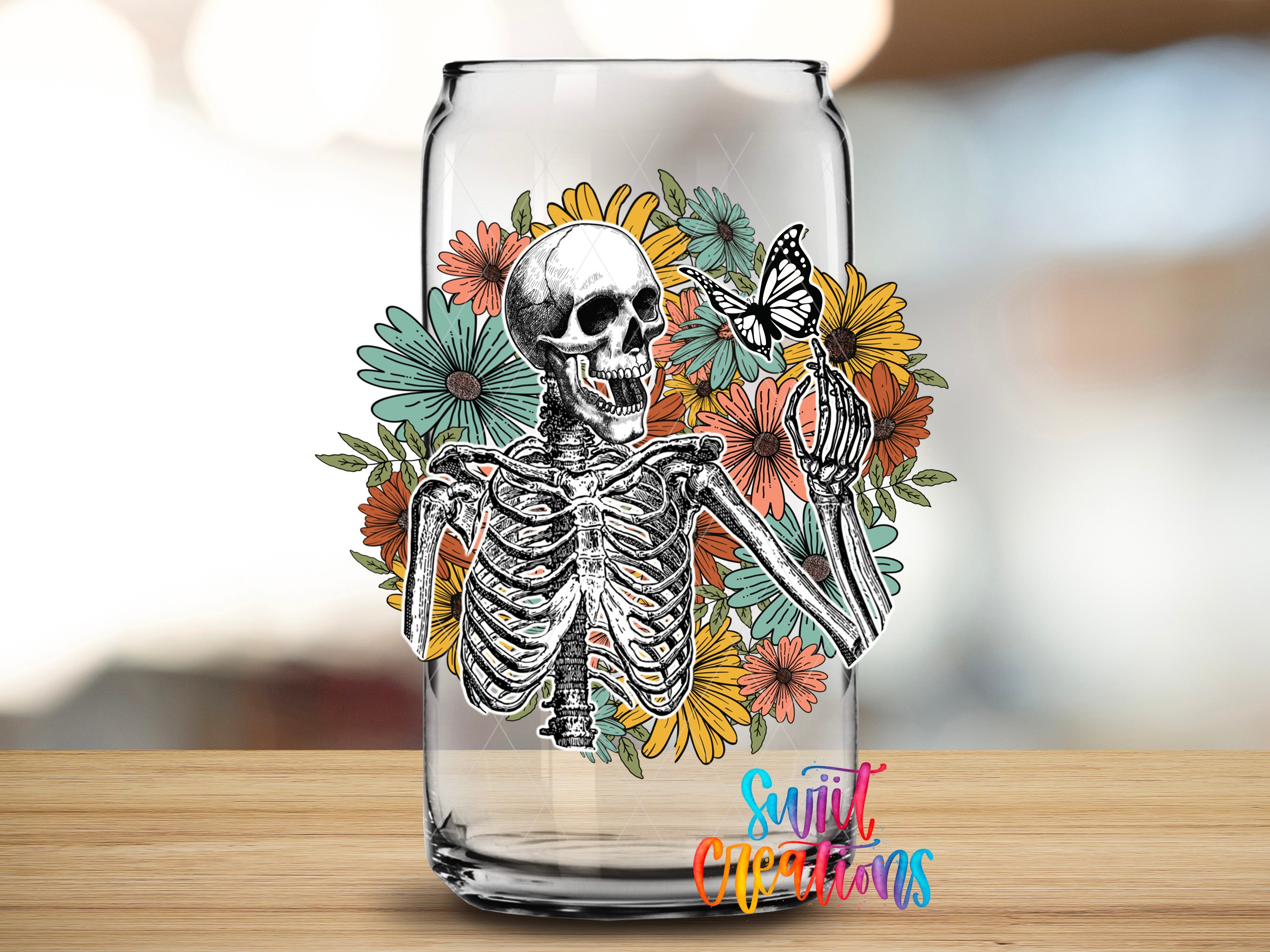 A glass can with a skeleton and colorful flowers printed on it.