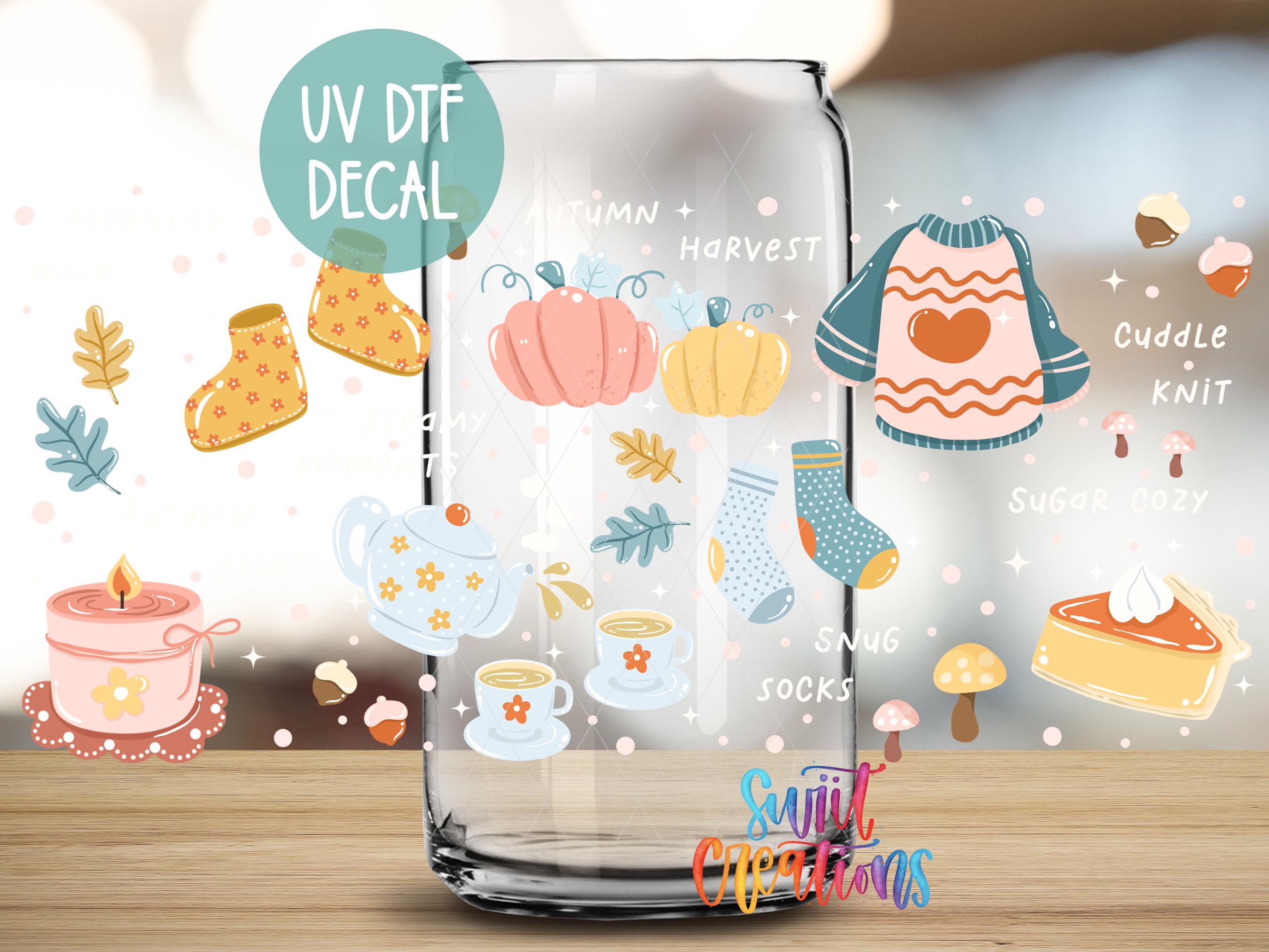 a glass jar with various fall-themed decals and illustrations, including a pumpkin, a sweater, a teapot, and other seasonal items.