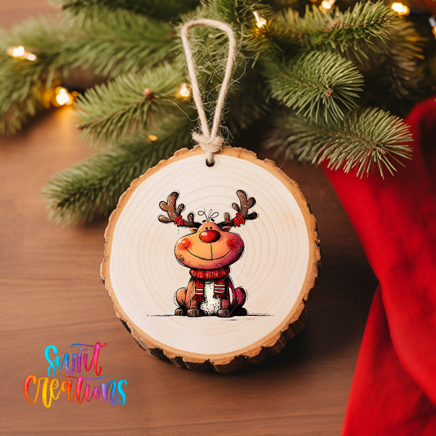 A wooden ornament featuring a cartoon reindeer is hanging on a Christmas tree, surrounded by pine branches and twinkling lights.