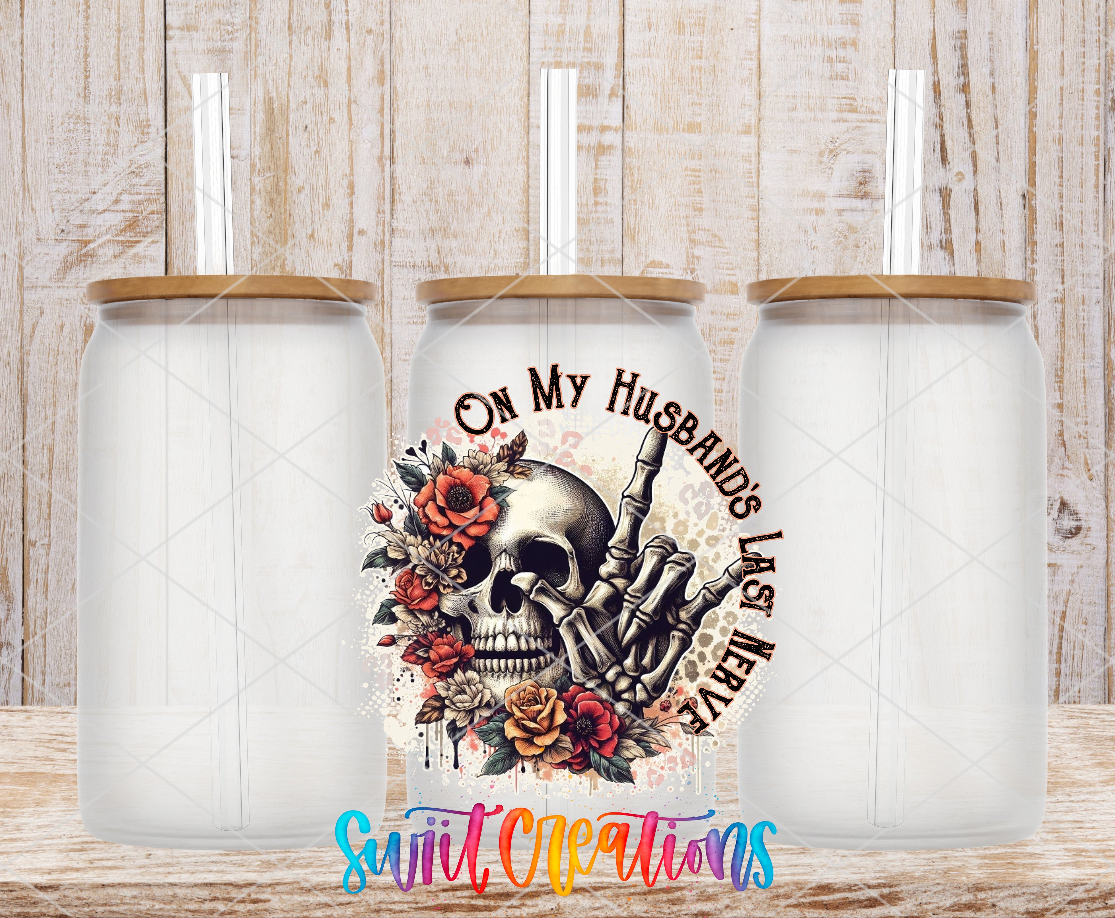 three clear glass mason jars with wooden lids, each with a straw inserted. The jars are arranged in a row, and there is a colorful graphic design on the center jar that includes a skull and floral elements.