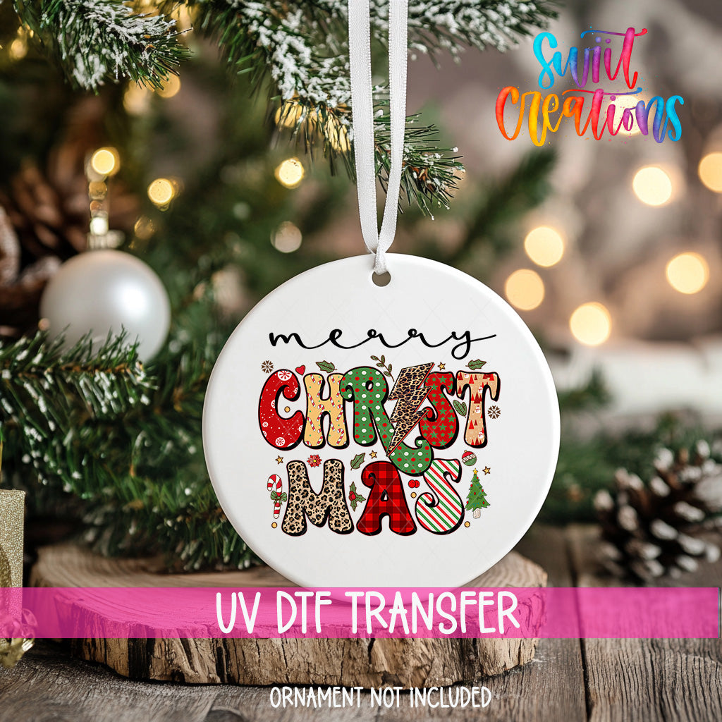 A white Christmas ornament with the text "MERRY CHRISTMAS" printed on it, hanging on a decorated Christmas tree.