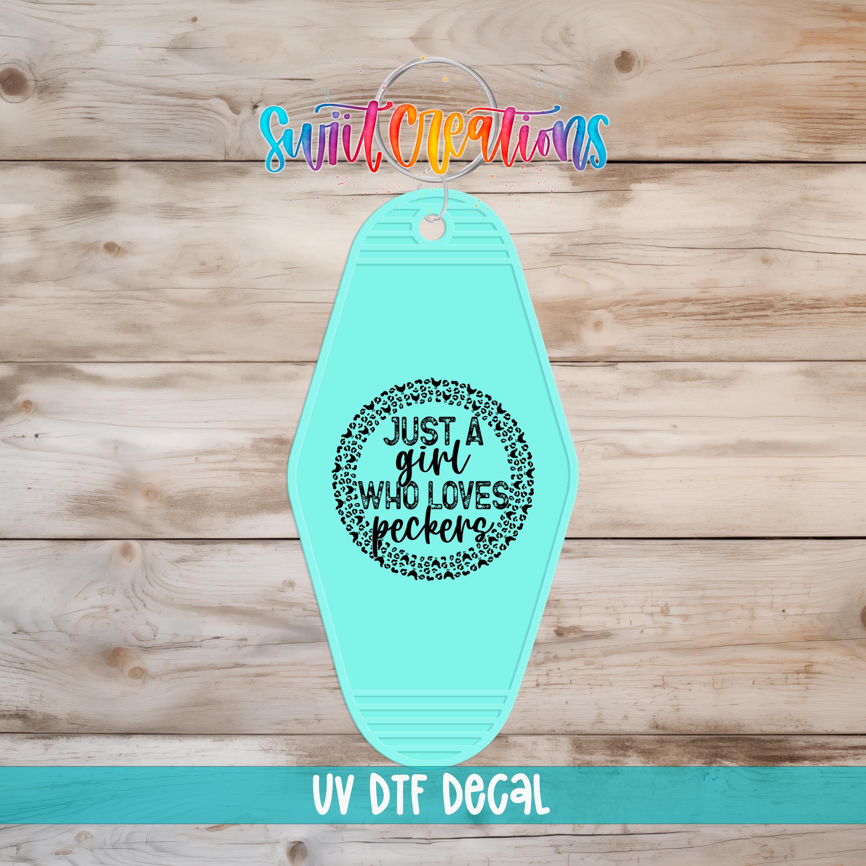 A turquoise keychain with a black and white text design that says "Just a girl who loves peckers" and "UV Dtf Decal" printed on it.