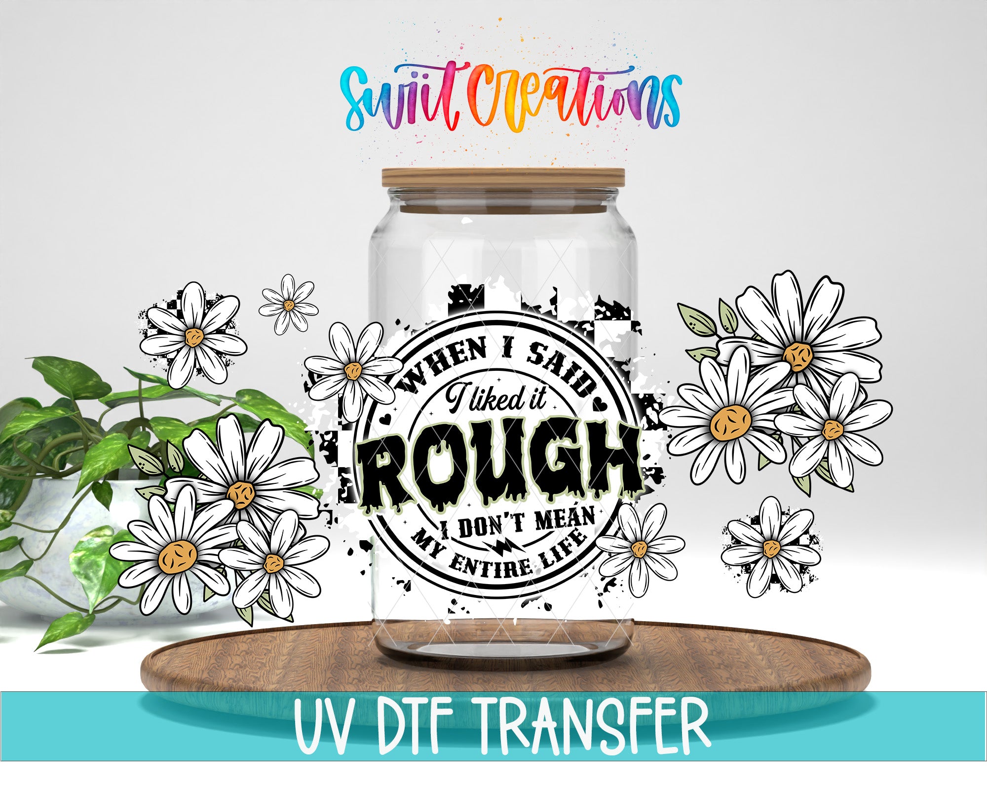 a clear glass jar with a printed design on it, surrounded by white flowers and a wooden tray. The text on the jar reads "When I said I like it rough, I don't mean my entire life".