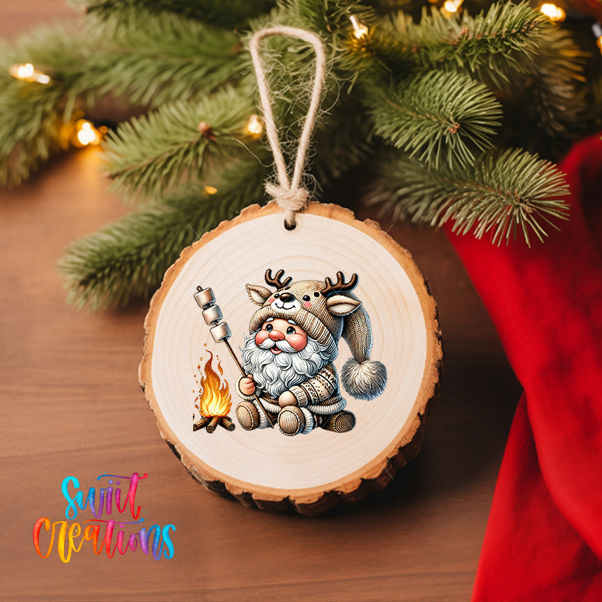 A wooden ornament featuring a cartoon Santa Claus character with antlers, holding a campfire, is hanging on a Christmas tree.