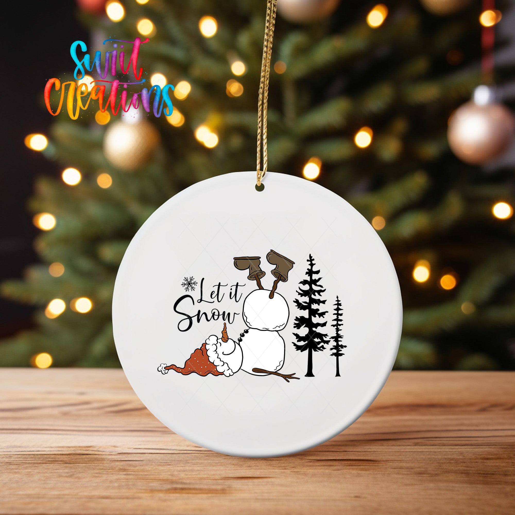 A white ceramic ornament with a snowman and trees, along with the text "Let it Snow" hanging from a string.