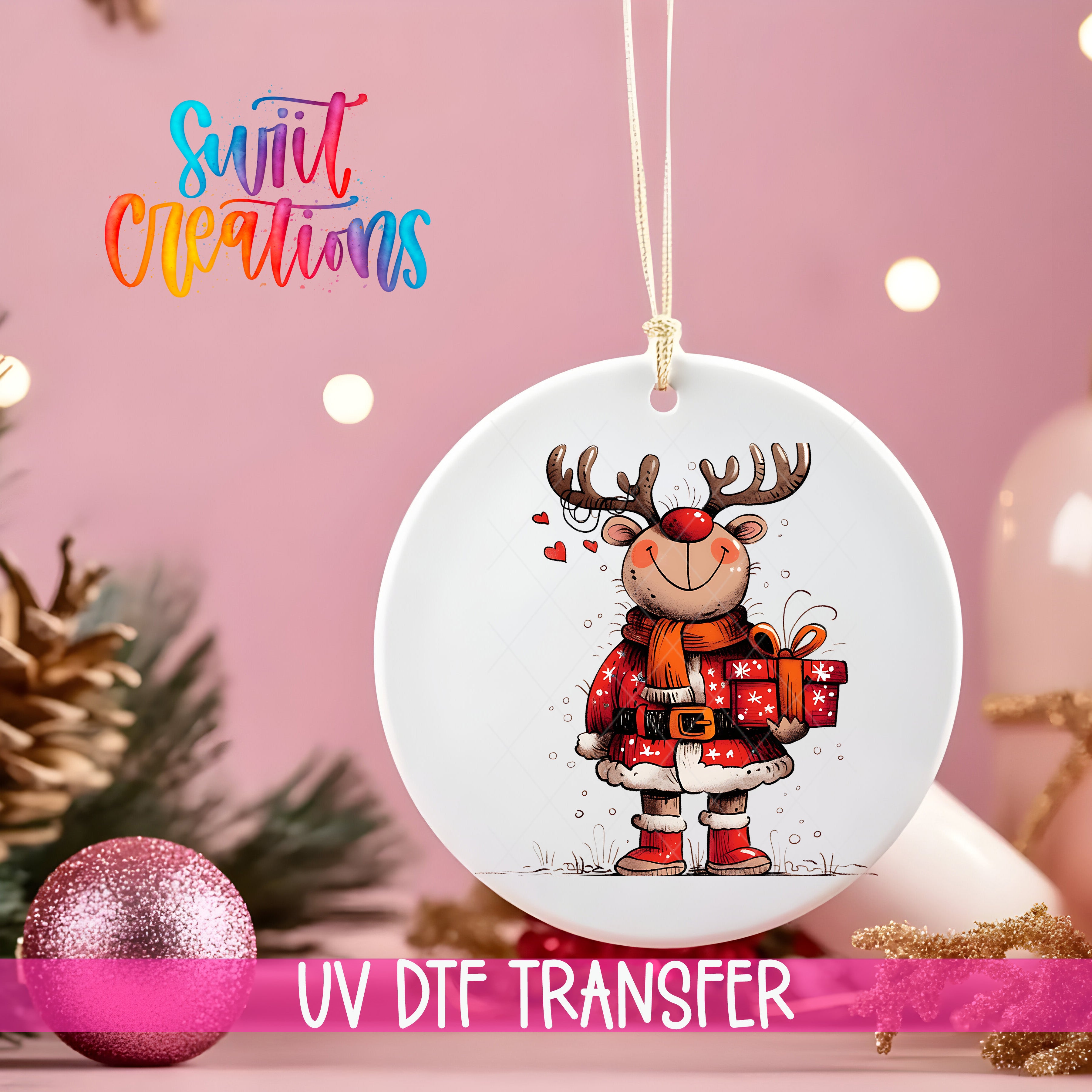 A white ornament with a cartoon reindeer holding a gift, hanging on a string against a pink background with Christmas decorations in the background.