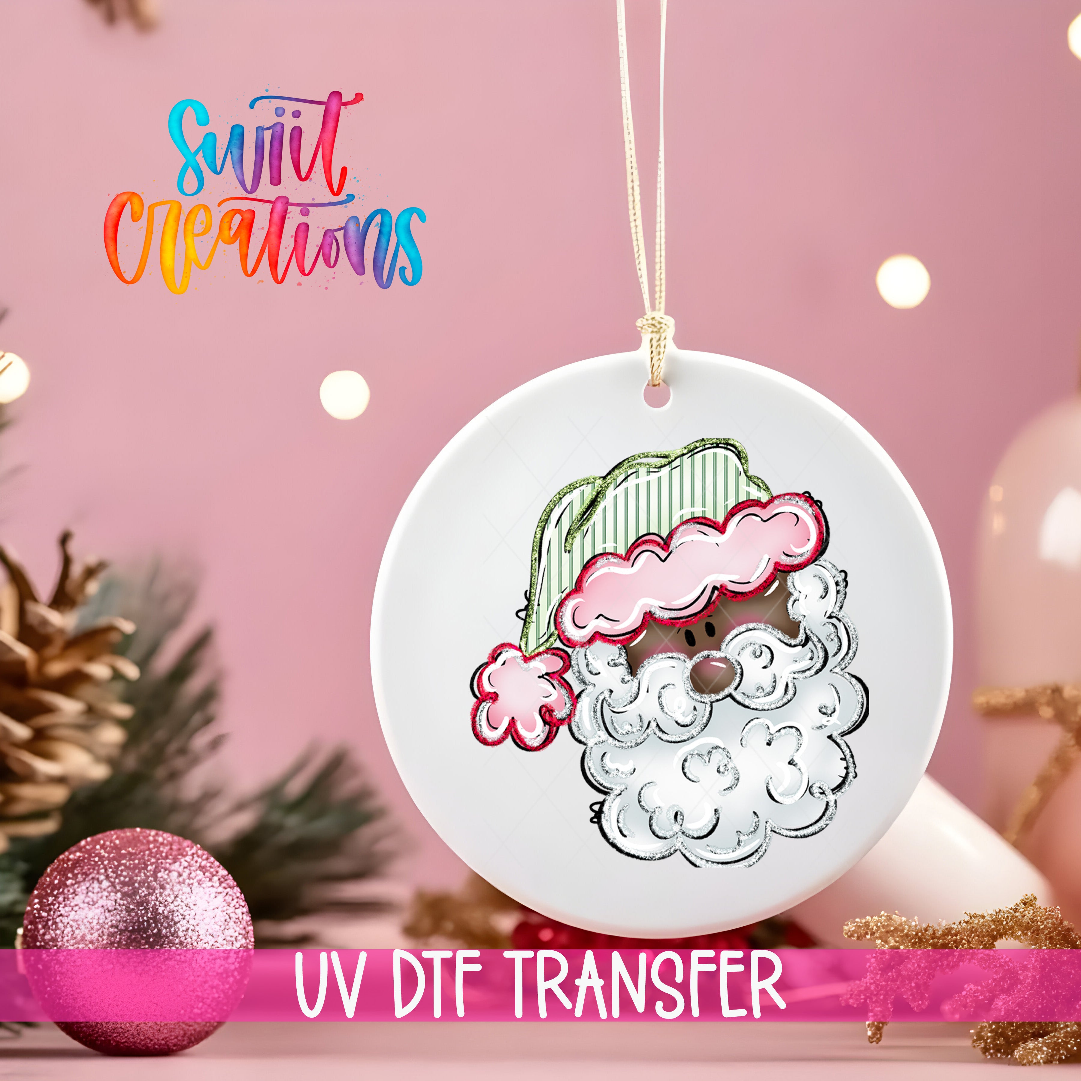 A white ornament with a Santa Claus face design hangs against a pink background, accompanied by a pink glitter ornament and Christmas lights.