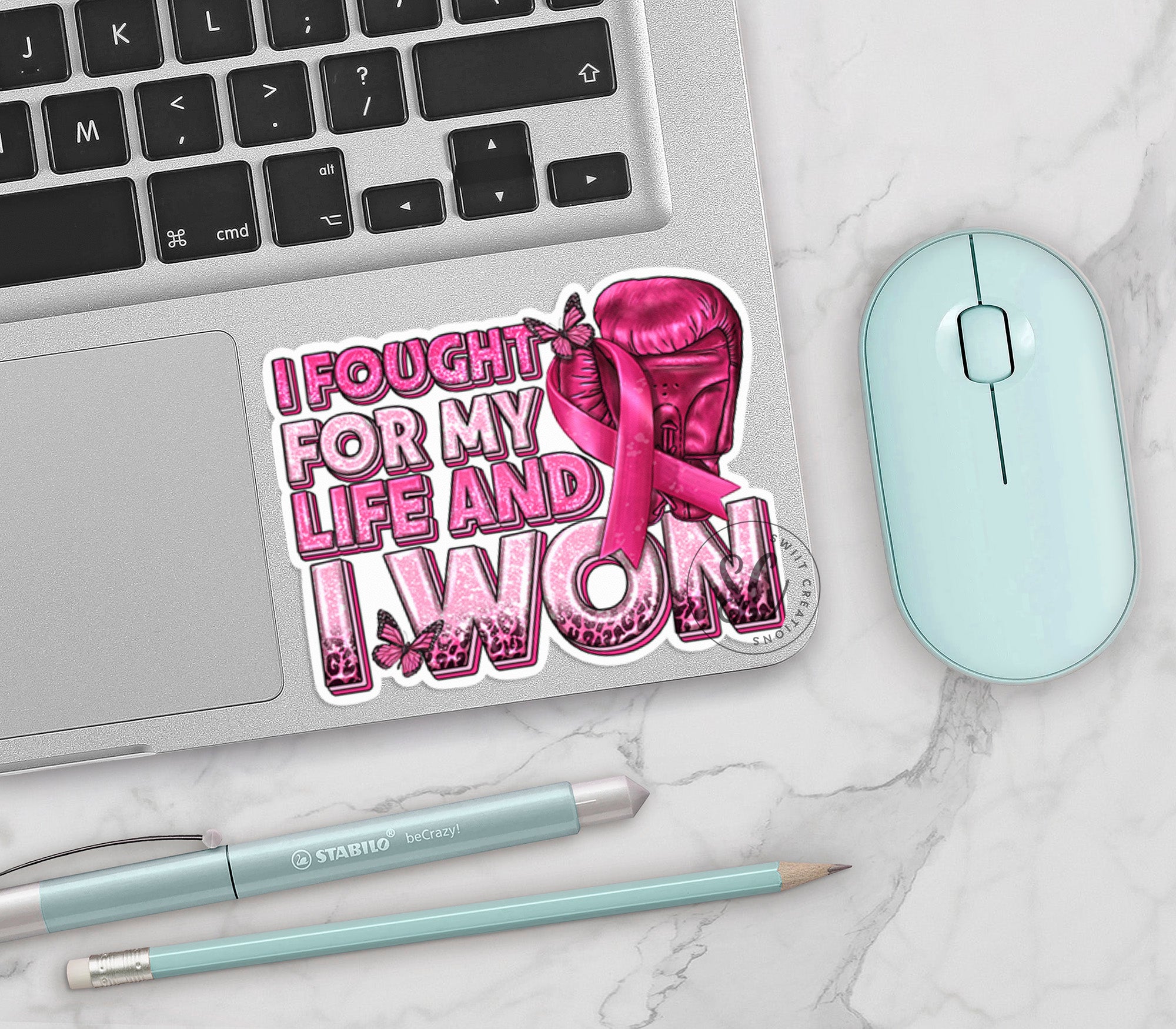 a laptop with a sticker on it next to a mouse