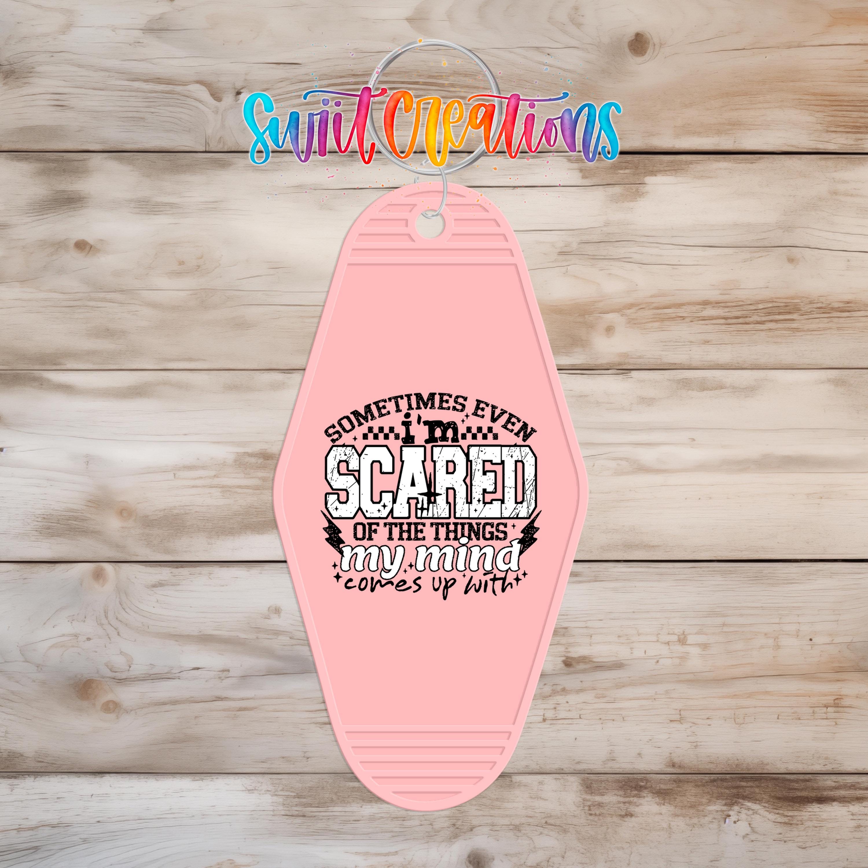 A pink keychain with a printed message that says "Sometimes even scared of the things my mind comes up with".