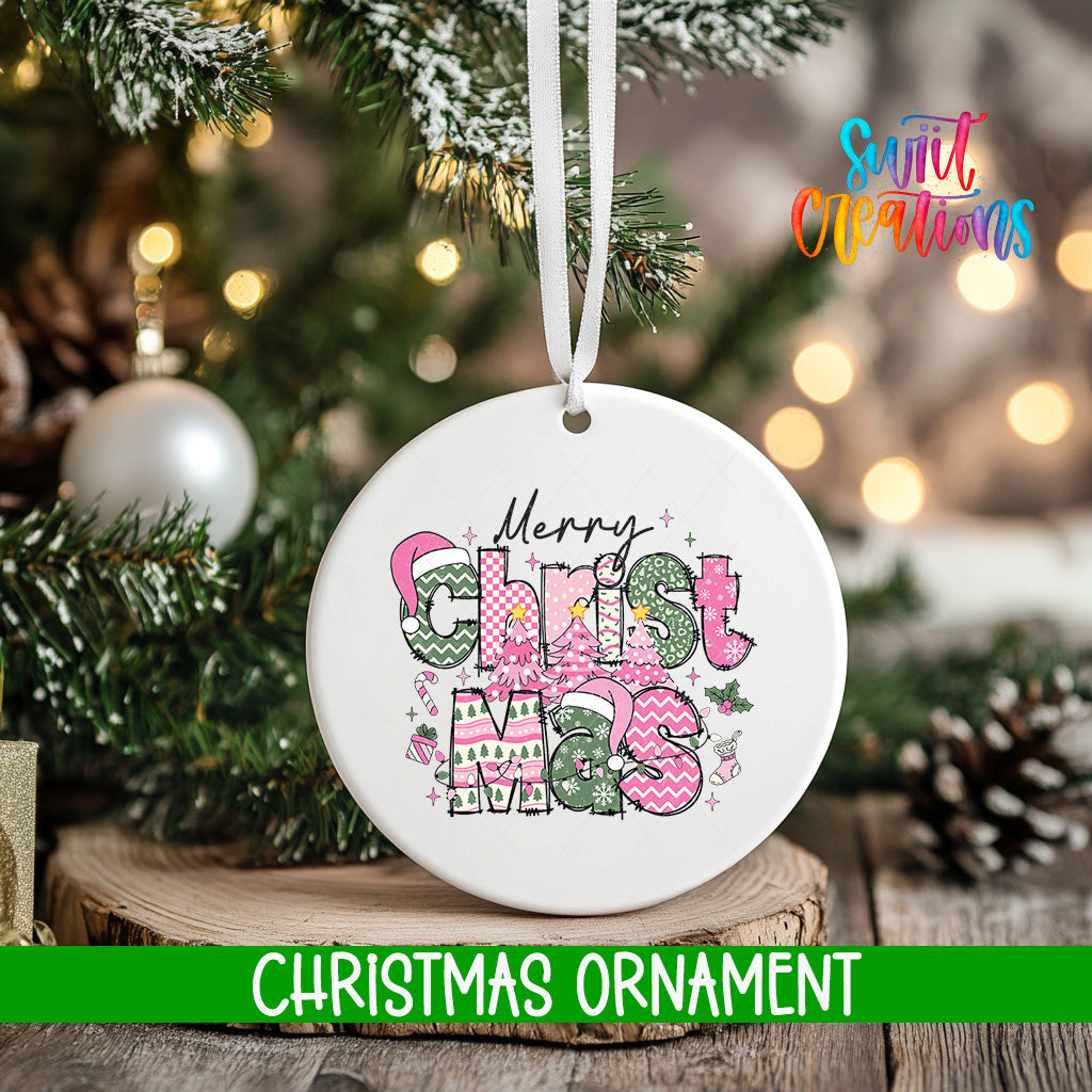 A white Christmas ornament with the text "Merry Christmas" and various Christmas-themed decorations hangs on a tree branch.