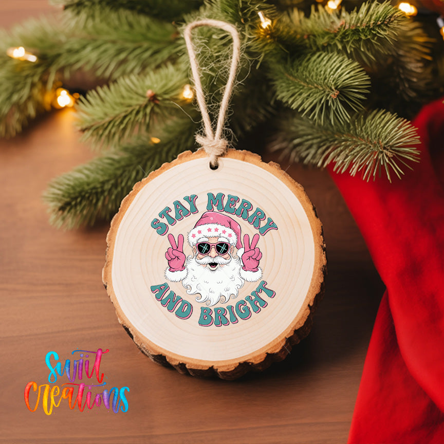 A wooden ornament with a Santa Claus design and the text "Stay Merry and Bright" hanging on a Christmas tree.