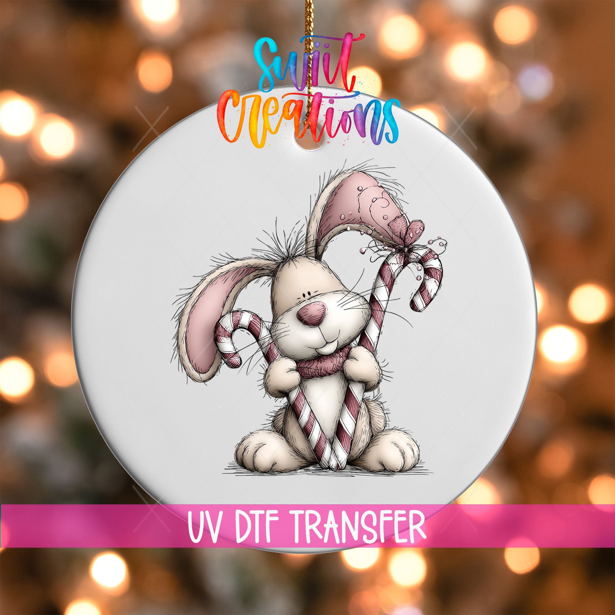A white ornament with a cartoon rabbit holding candy canes and a bow, set against a background of colorful lights.