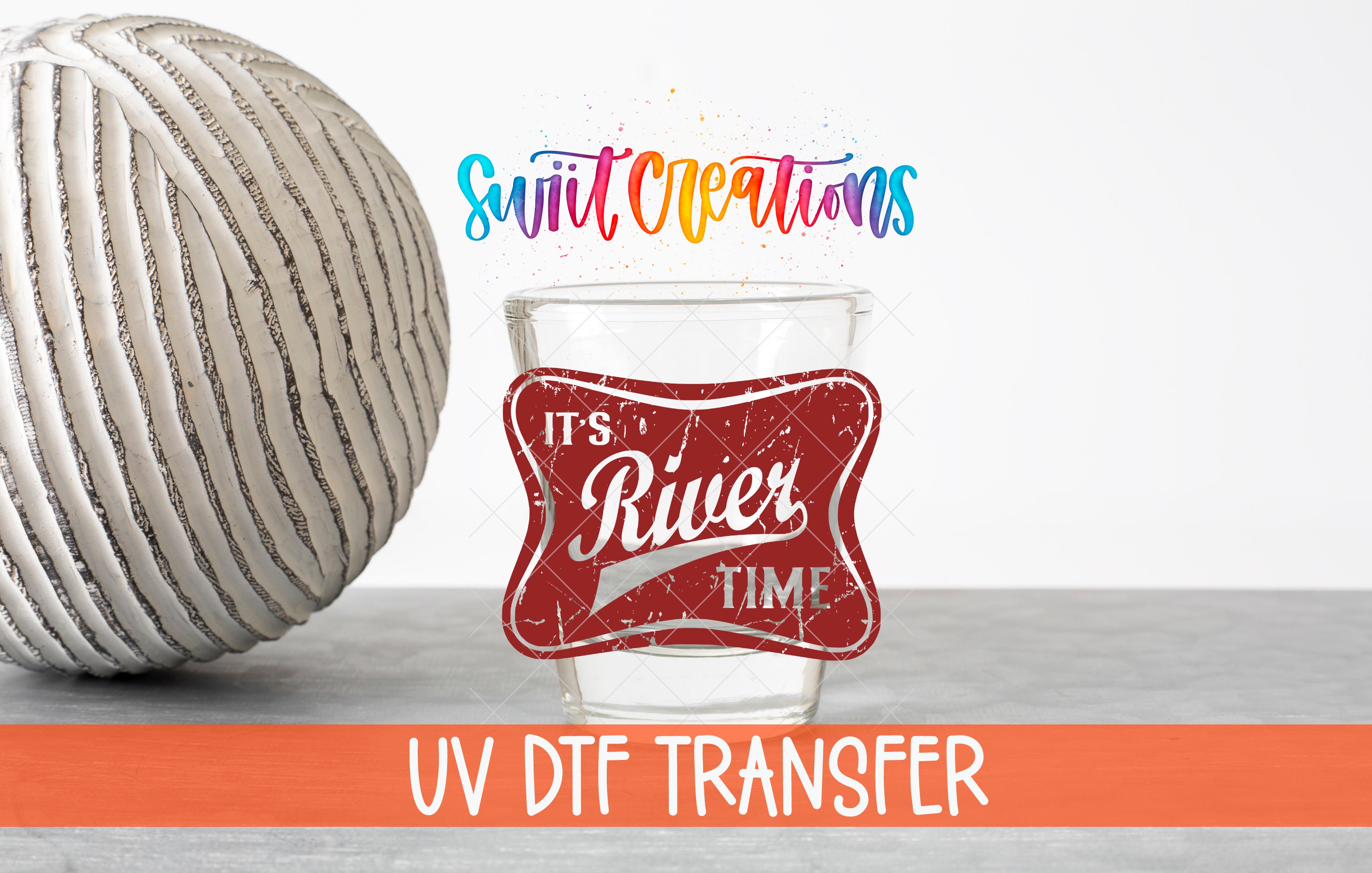 a glass with a red label that says "It's River Time" and a white ball with a striped pattern. The text "Swift Creations" is written above the glass, and "UV DFT Transfer" is written below the glass.