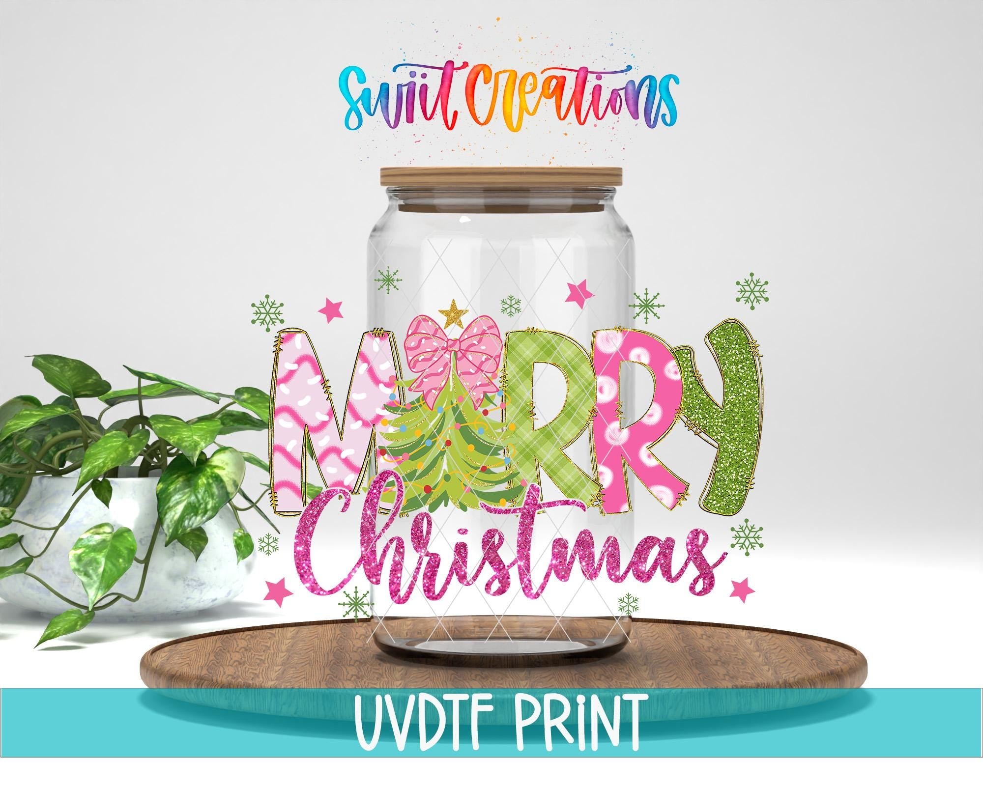 A glass jar with a lid, decorated with colorful text and snowflakes, placed on a wooden surface.
