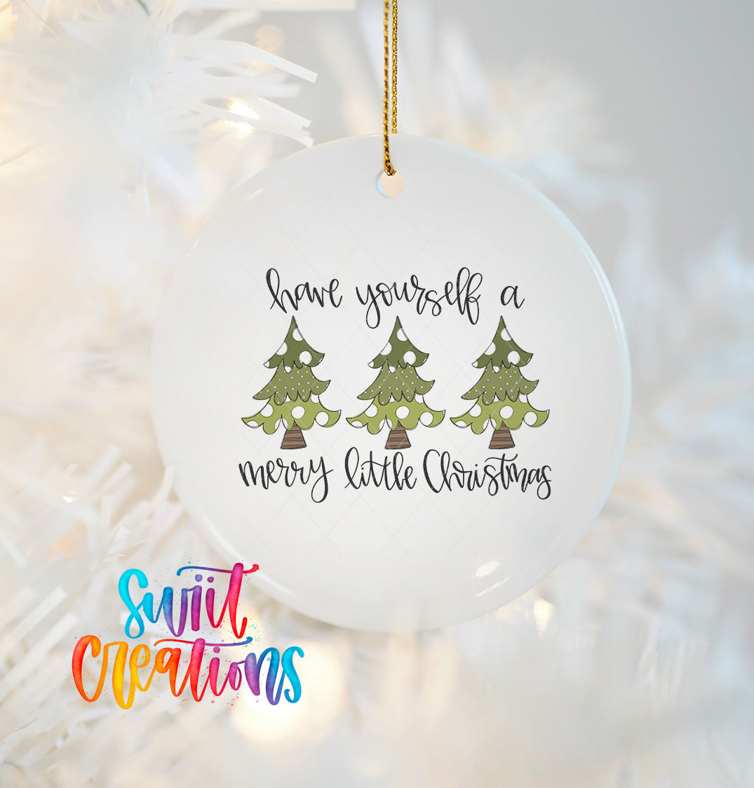 A white ceramic ornament with a Christmas tree design and the text "Have yourself a merry little Christmas" hanging on a string.