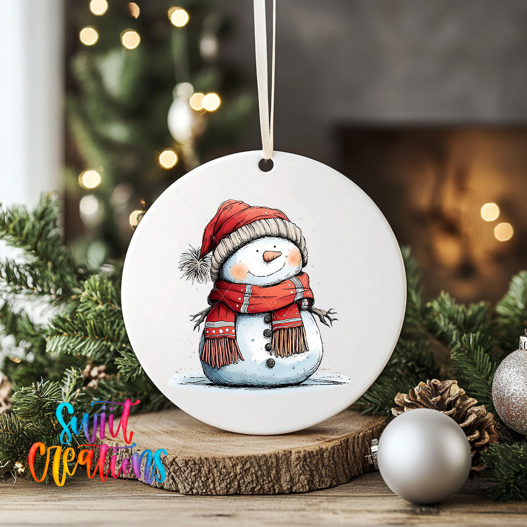 A white snowman ornament with a red scarf and hat is displayed on a wooden surface, surrounded by Christmas decorations and greenery.
