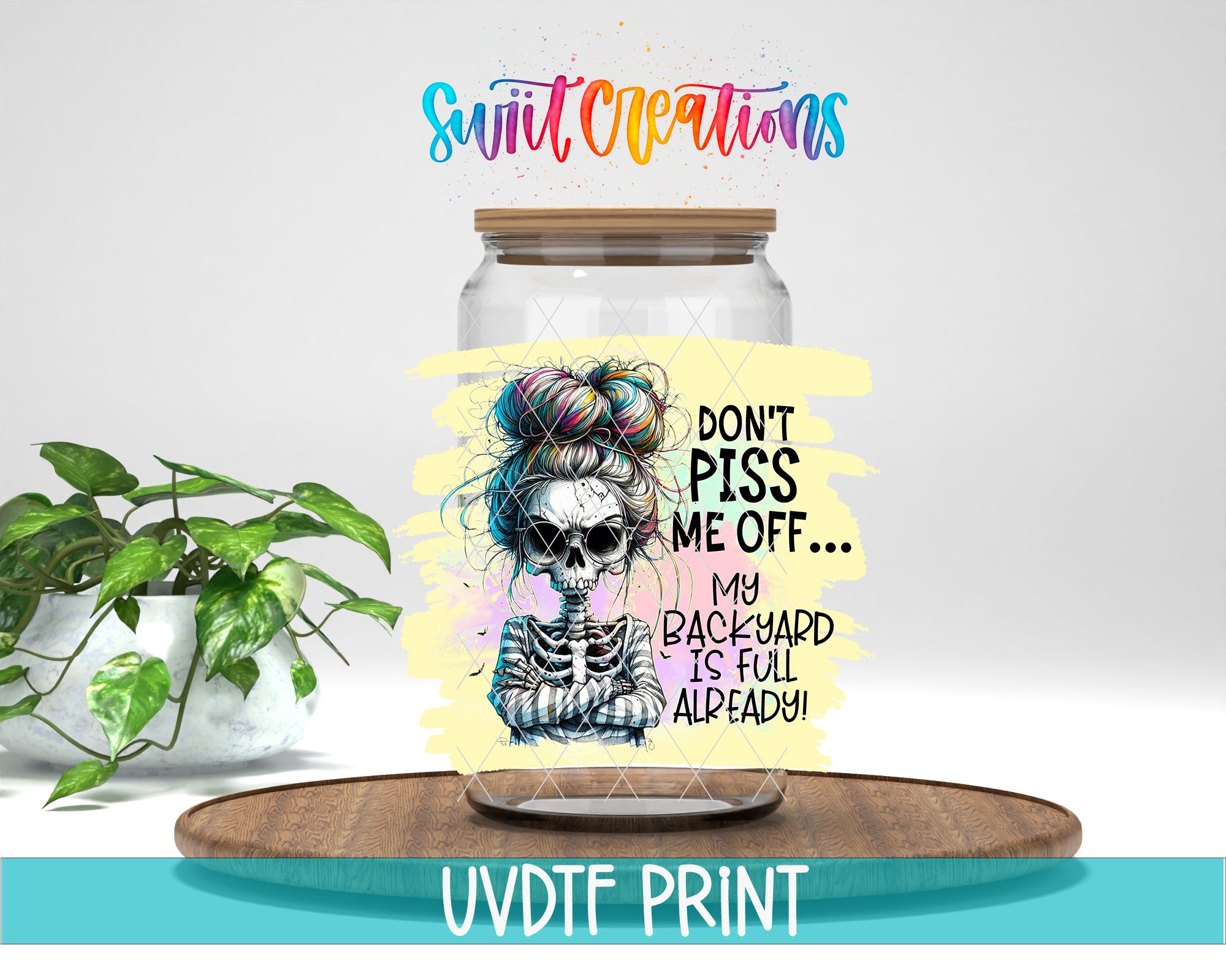 a glass jar with a skeleton design and a colorful, artistic label that says "Don't Puss Me Off... My Backyard Is Full Already!" The jar is placed on a wooden surface, and there is a potted plant in the background.