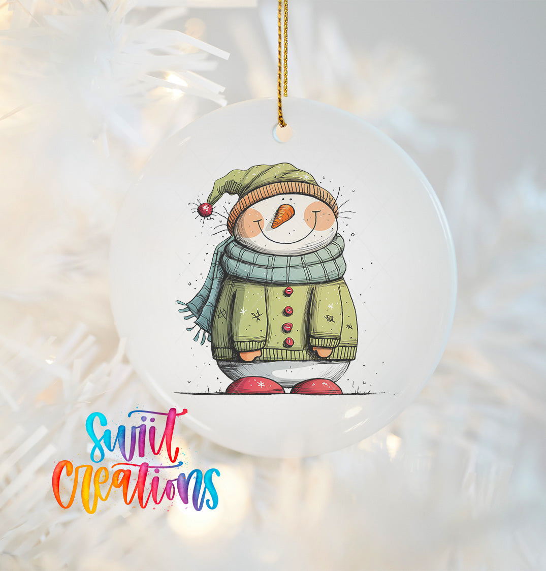 A snowman ornament with a green sweater and red shoes, wearing a green hat and scarf, is hanging on a Christmas tree.